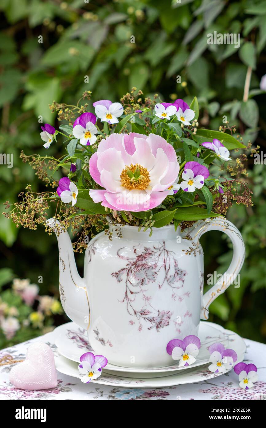 bouquet di fiori di peonia rosa e di viola in porcellana d'annata caffè lattina Foto Stock
