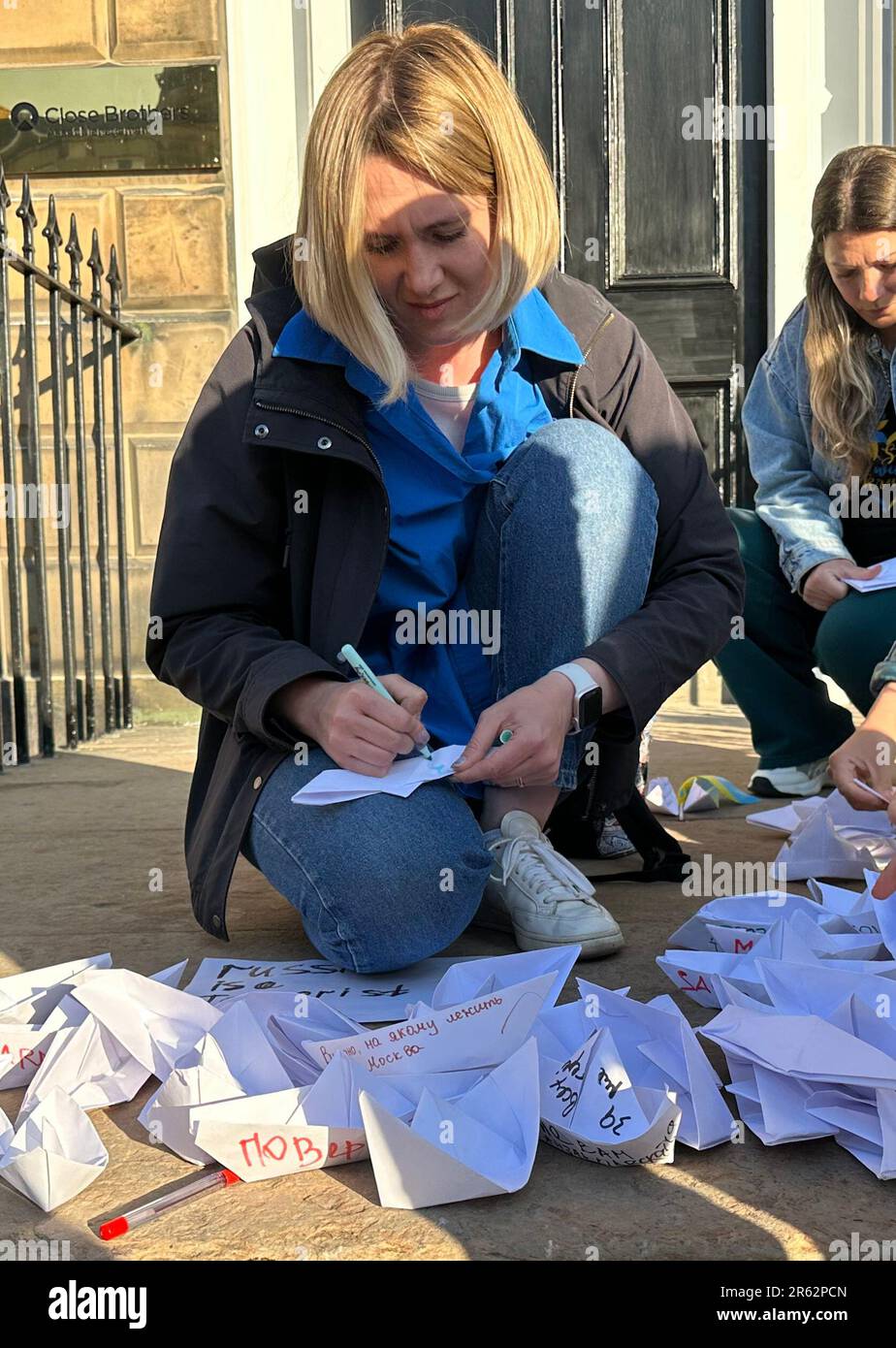 Manifestanti al di fuori del consolato russo a Edimburgo, dove hanno denunciato la Russia come uno "Stato terrorista”. Gli ucraini che chiedono alle forze di Vladimir Putin di lasciare la loro patria hanno lasciato messaggi su barche di carta per il personale del consolato da leggere dopo che una grande diga è stata danneggiata. Data immagine: Martedì 6 giugno 2023. Foto Stock