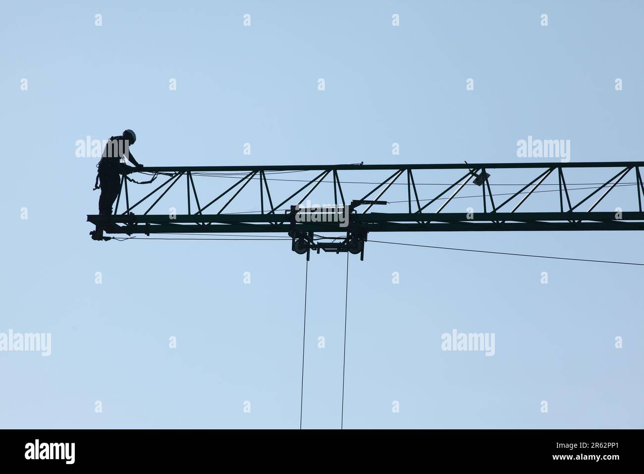 Un lavoratore di costruzione è rappresentato sopra una gru grande senza ruote, pronto a lavorare su un progetto di costruzione Foto Stock