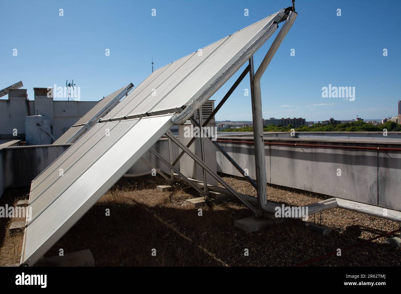 Questa foto presenta un tetto moderno con pannelli fotovoltaici montati contro l'edificio Foto Stock