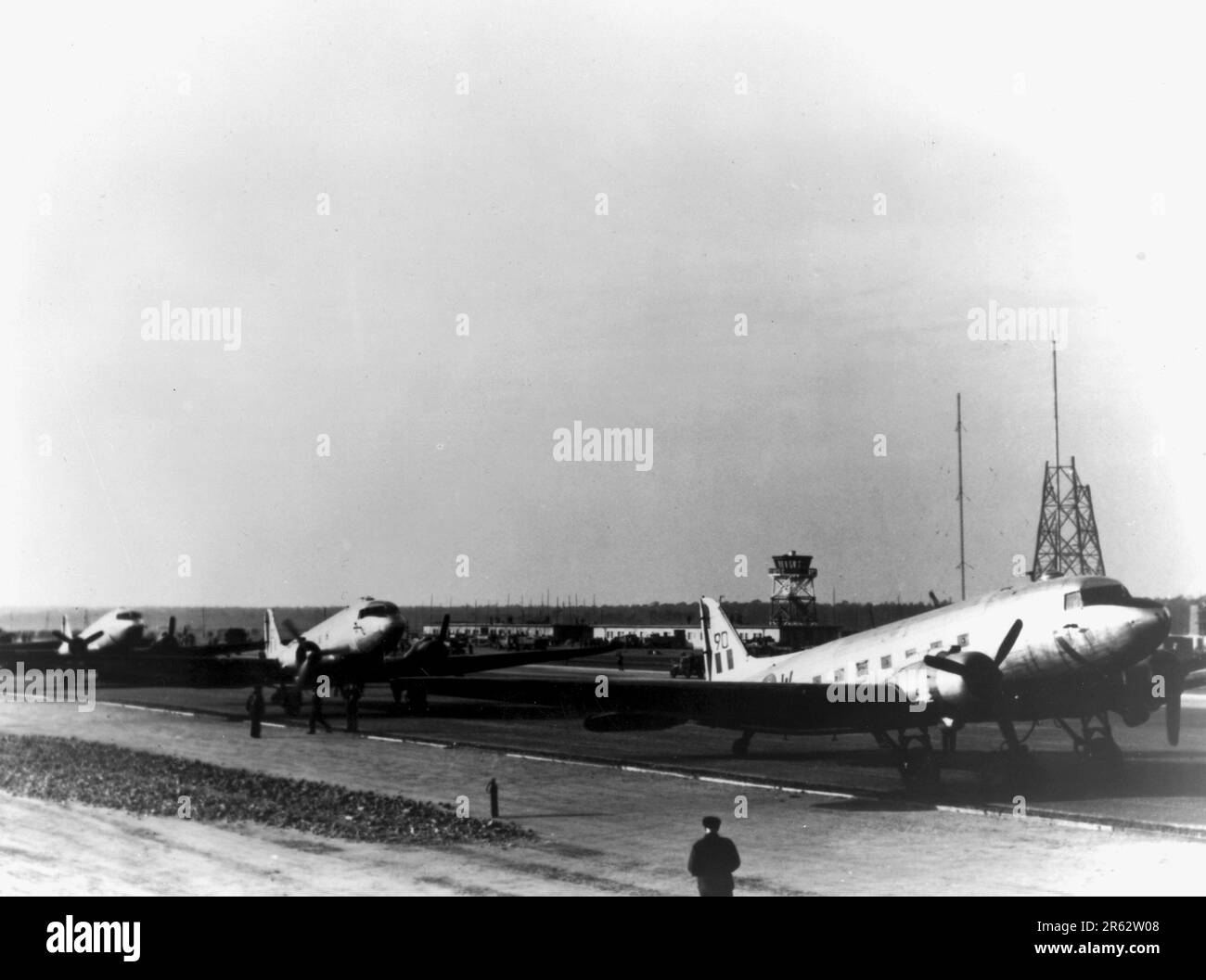 RAF Douglas C-47 Dakotas viene scaricata all'aeroporto Tegel di Berlino durante l'Airlift di Berlino. In risposta all'intensificarsi delle tensioni e alla creazione di una nuova moneta della Germania occidentale, i sovietici tagliarono tutte le comunicazioni terrestri verso Berlino Ovest e smisettarono di inviarci cibo. La risposta di TheAllied è stata una campagna di undici mesi per fornire a W Berlin le 5000 tonnellate al giorno di cibo e carburante di cui aveva bisogno. Un aereo atterrò ogni tre minuti giorno e notte e l'operazione fu così succesiva che i sovietici dovettero tornare indietro e riaprire le strade, le ferrovie e i canali. Foto Stock