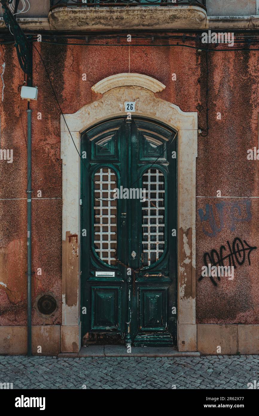 Un'immagine verticale dell'esterno di una vecchia porta in una parete intemperiata Foto Stock