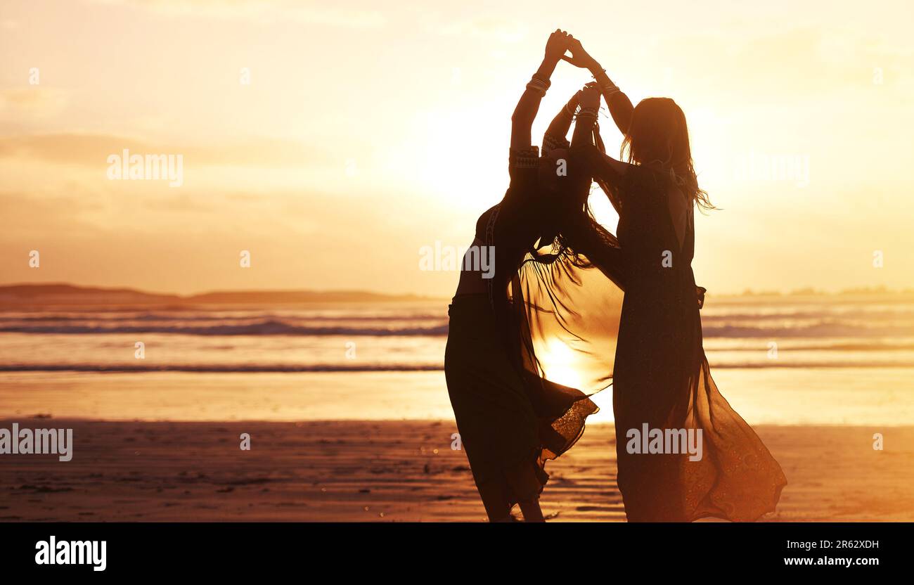 Scorre liberamente e amorevolmente con la vita. due giovani donne trascorrono la giornata in spiaggia al tramonto. Foto Stock