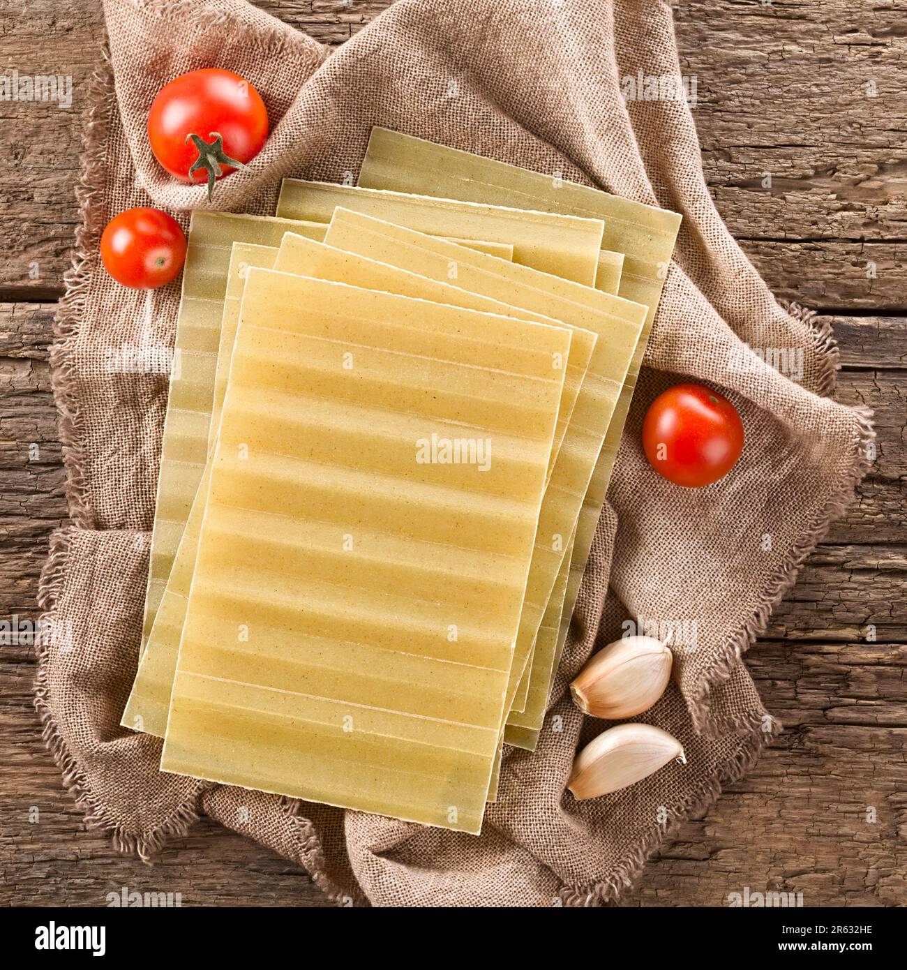 Sfoglia di lasagne rigate a secco, non cotte, fotografata sopra su legno rustico Foto Stock