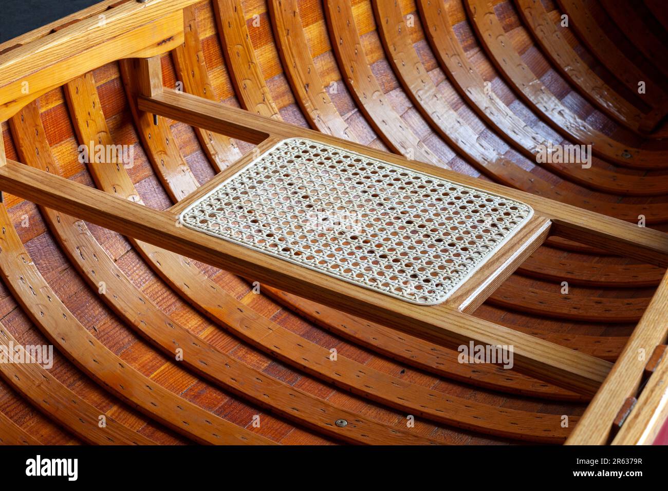Primo piano interno di una canoa in legno e di un sedile a canne Foto Stock