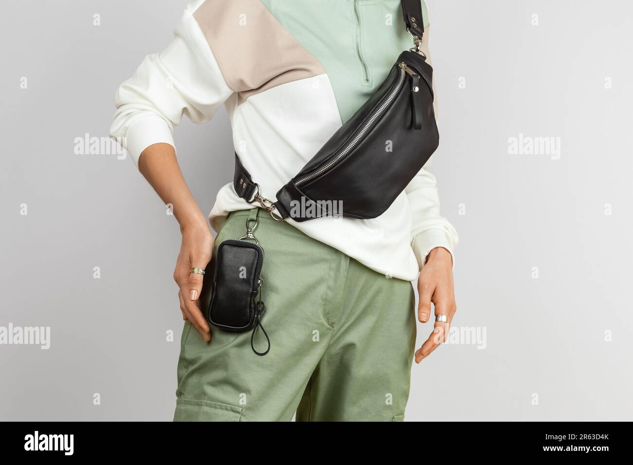 Custodia piccola in pelle per sigaretta elettronica attaccata alla vita e Fanny in vera pelle sul modello femminile su sfondo grigio, Studio Shot Foto Stock