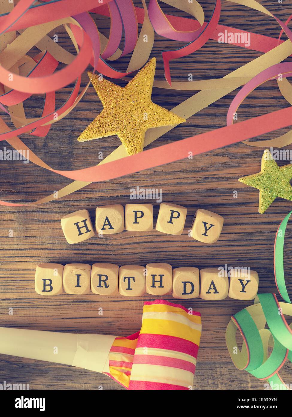 Buon compleanno, dadi di legno su una woodent in grado con decorazione di compleanno, vintage stilizzato di colore Foto Stock