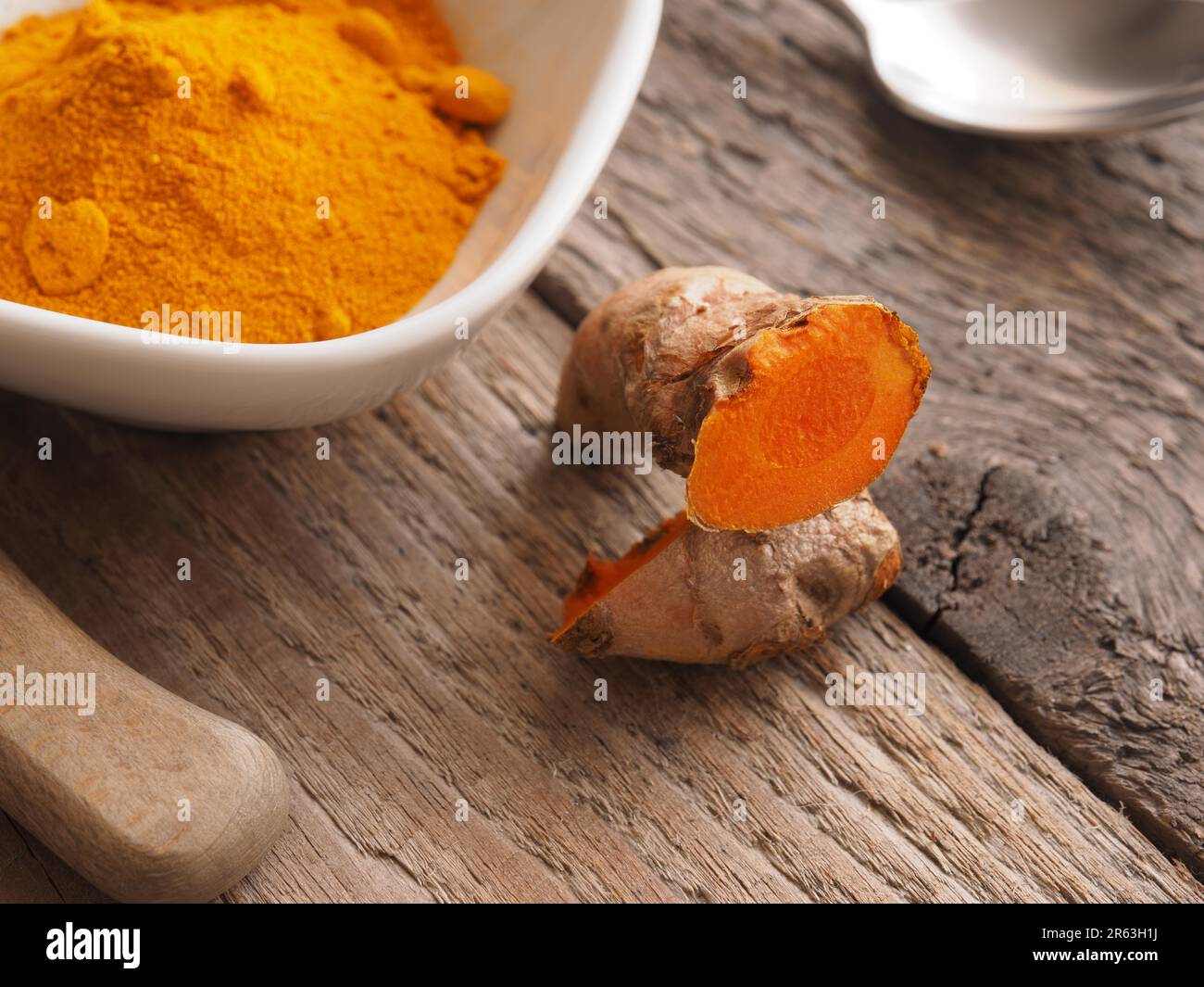 Curcuma rizoma e polvere su una tavola in legno rustico, vista da sopra Foto Stock