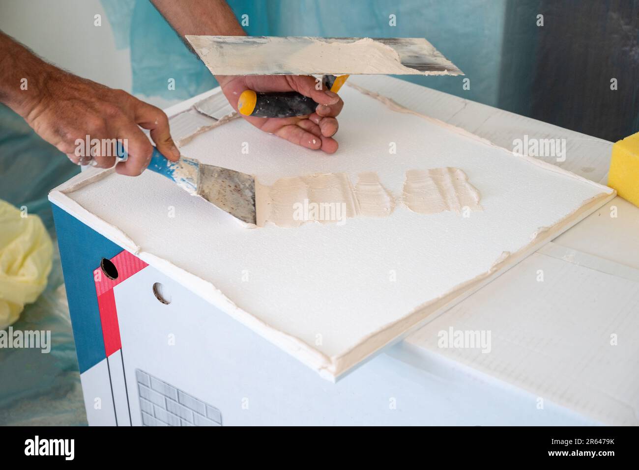 applicazione di intonaco adesivo di piastrelle styrofoam soffitto di una cucina domestica Foto Stock