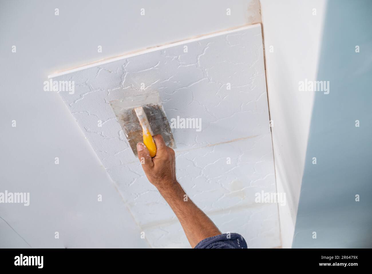 applicazione di intonaco adesivo di piastrelle styrofoam soffitto di una cucina domestica Foto Stock