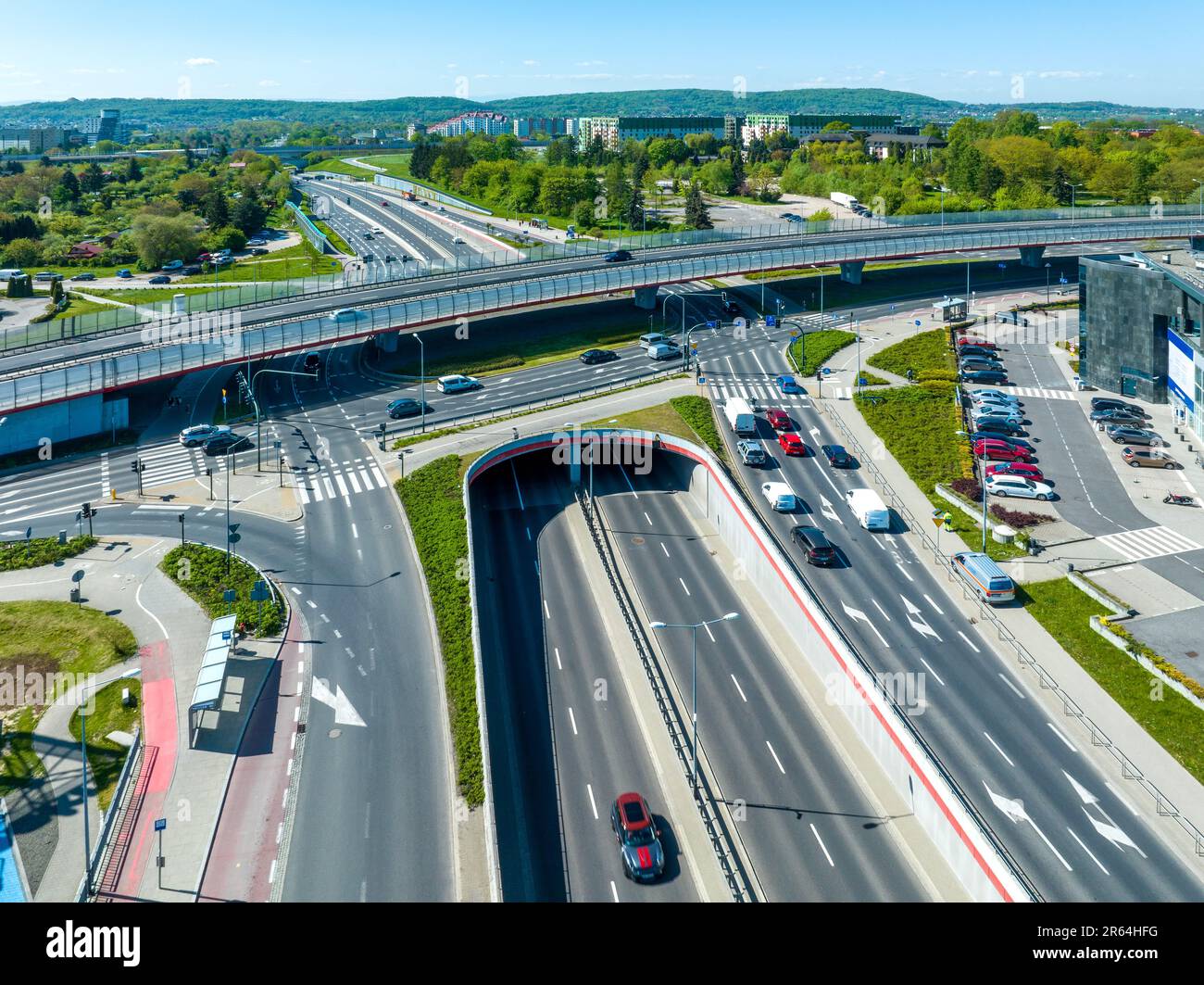 Raccordo autostradale multilivello a Cracovia, Polonia. Un'autostrada al piano superiore, la seconda nel tunnel, la svolta con semafori e. Foto Stock