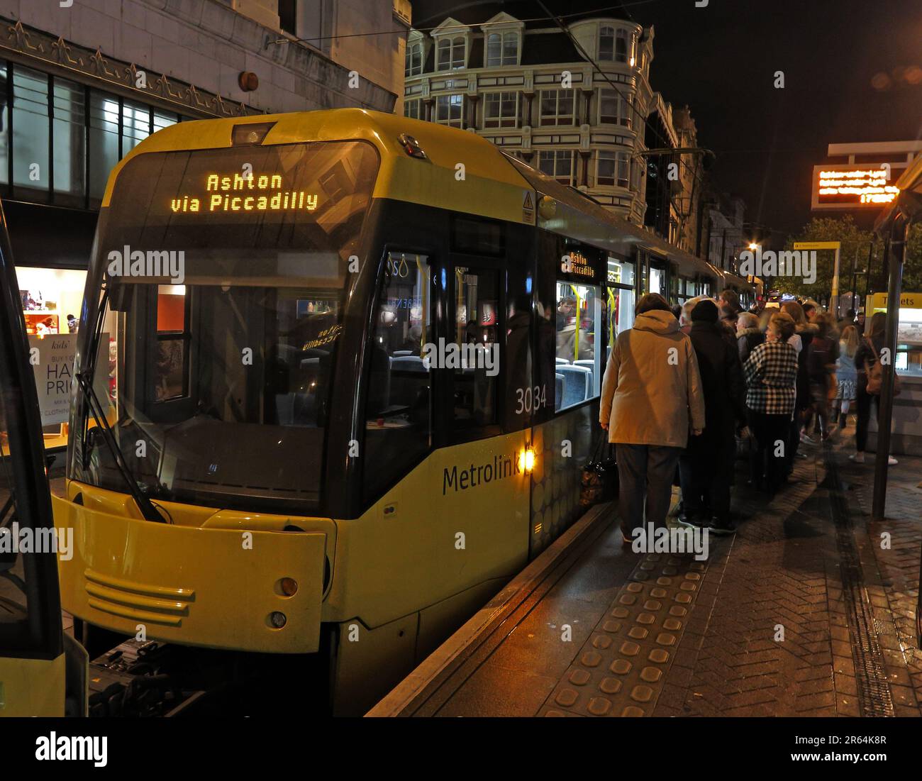 Metrolink Manchester tram per Ashton via Piccadilly, in una serata piovosa, in Market Street, Manchester, Lancashire, Inghilterra, REGNO UNITO, M1 1PW Foto Stock