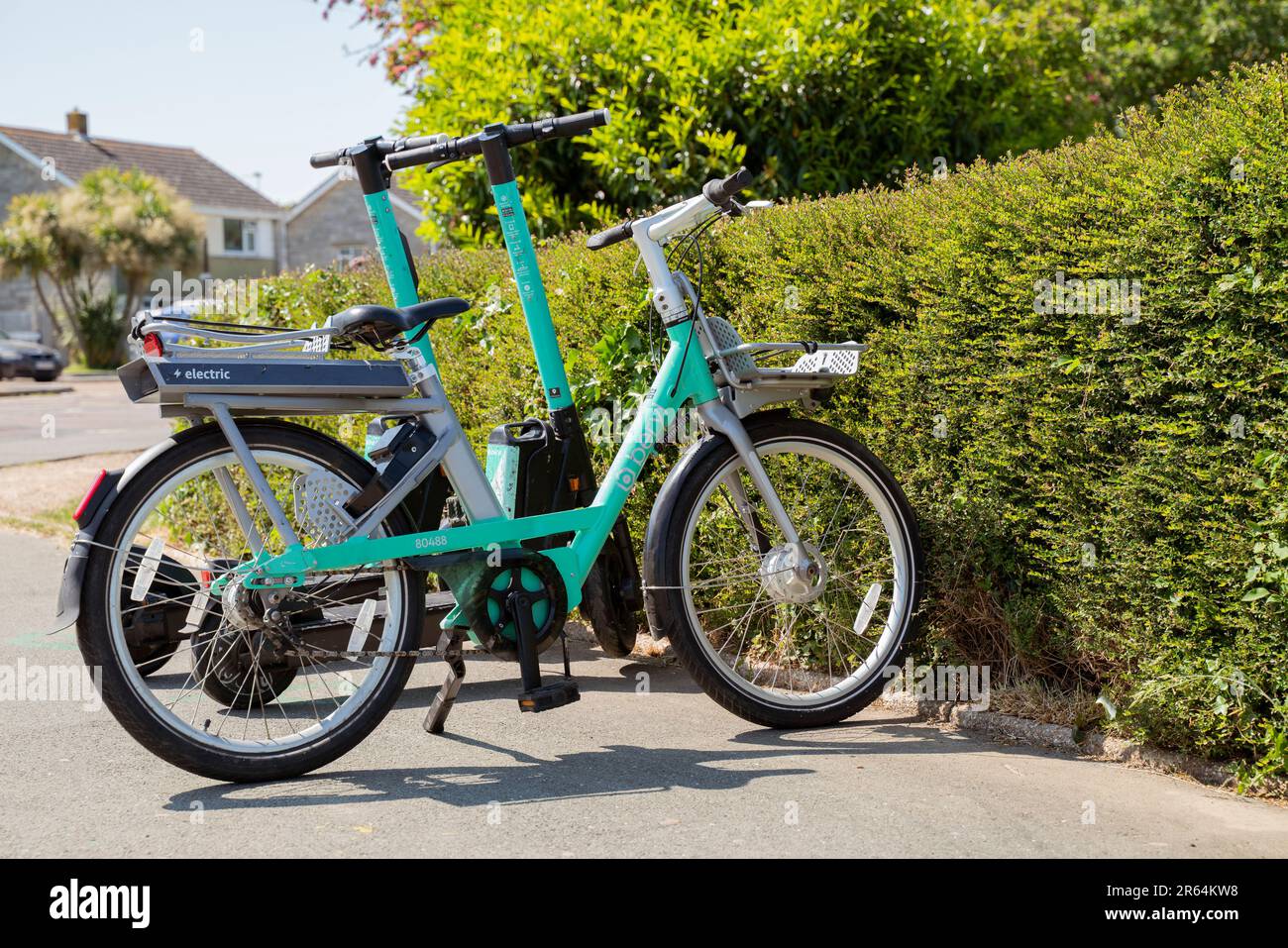 Bici elettrica beryl e scooter elettrici Beryl in un angolo di strada a Newport, Isola di Wight, disponibili a noleggio. Foto Stock