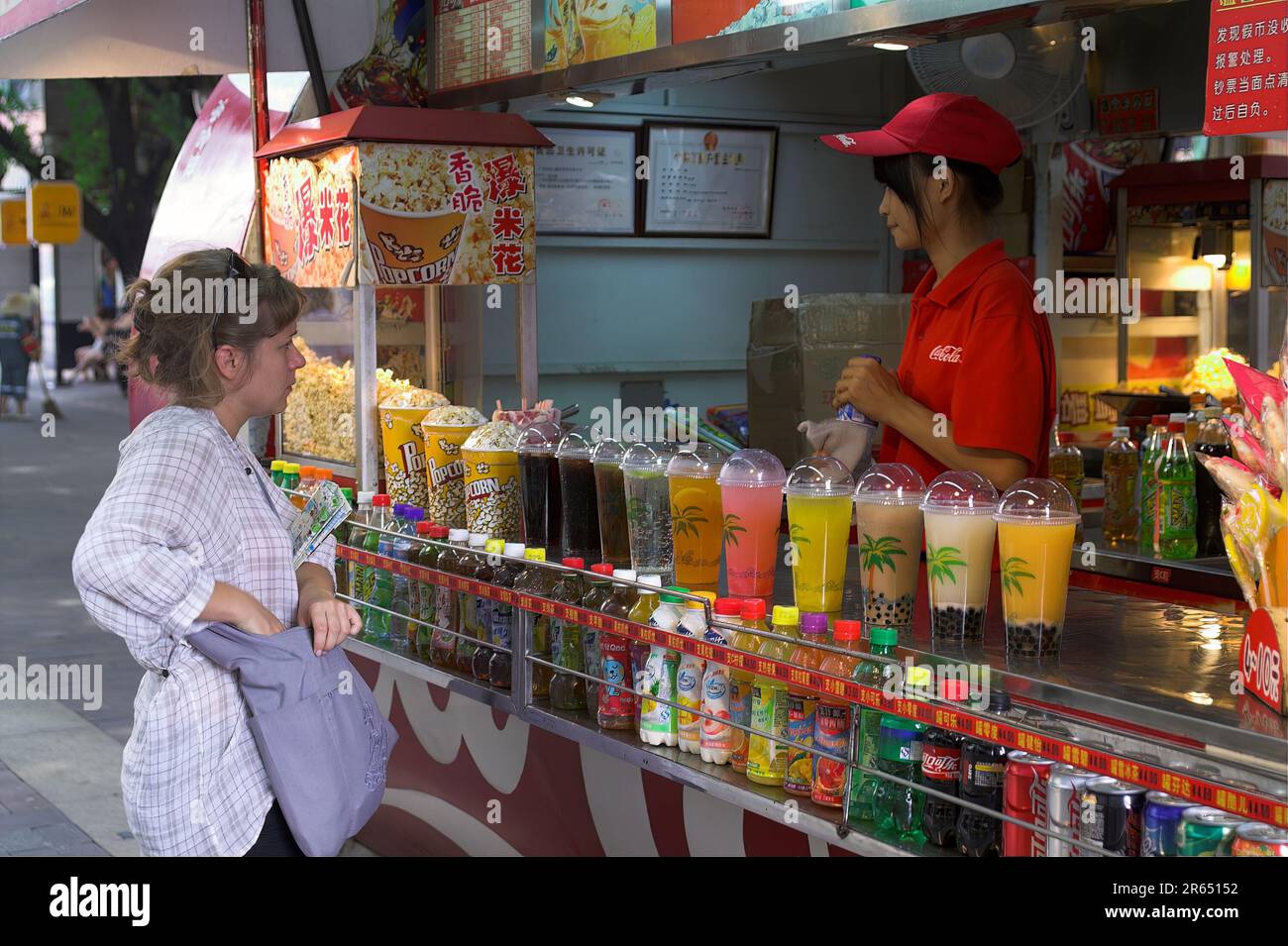 广州市 中國 Guangzhou, Cina; Un turista bianco acquista succo in una bancarella di strada. Ein Weißer Tourist kauft Saft an einem Straßenstand. 一名白人遊客在路邊攤買果汁。 Foto Stock