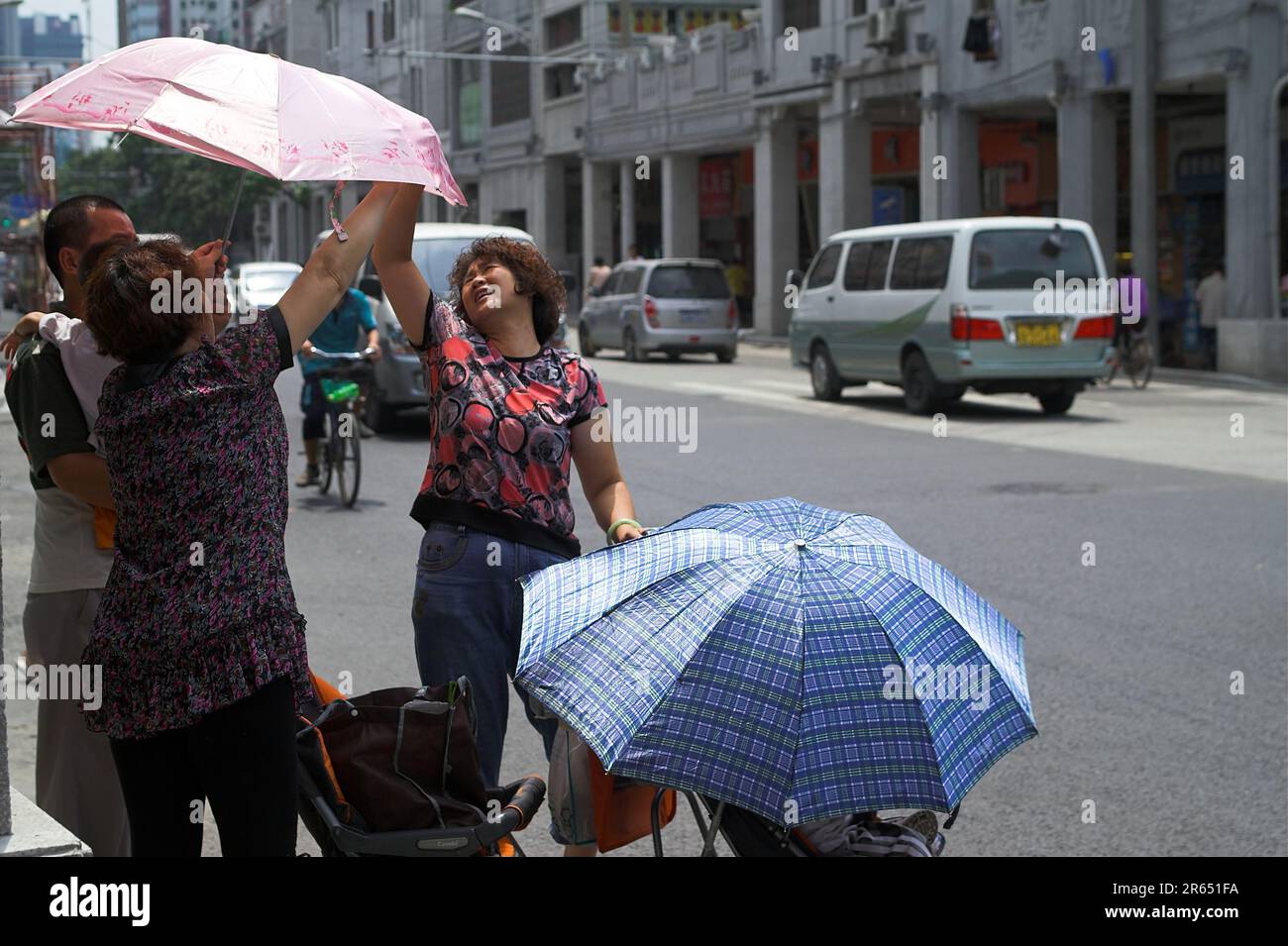 广州市 中國 Guangzhou, Cina; le donne cinesi diffondono un ombrello contro il sole; Chinesinnen breiten einen Regenschirm gegen die Sonne aus 中國婦女撐傘防曬 Foto Stock