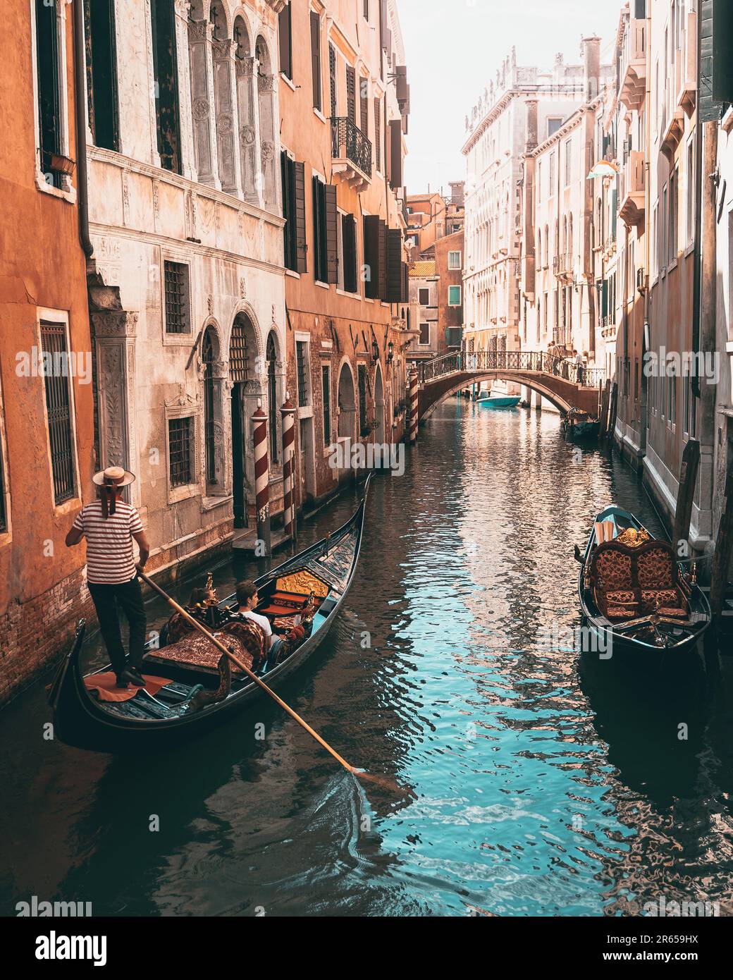 Due persone in canoa in una stretta via d'acqua vicino ad edifici urbani a Venezia Foto Stock