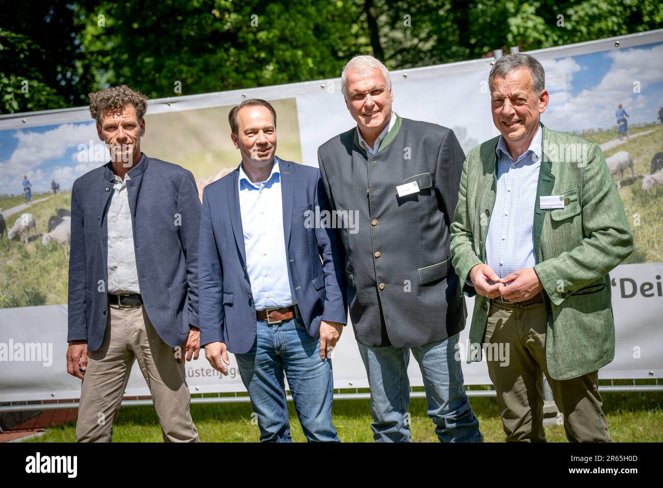 07 giugno 2023, bassa Sassonia, Aurich: Marcus Henke (l-r), presidente dell'Associazione dei cacciatori di Stato di Brema, Jörn Ehlers, vicepresidente dell'Associazione degli agricoltori dello Stato della bassa Sassonia, Gernold Lengert, vicepresidente distrettuale dell'Associazione dei cacciatori della Frisia Orientale, e Helmut Dammann-Tamke, presidente dell'Associazione dei cacciatori di Stato della bassa Sassonia, si trovano di fronte ai nuovi manifesti. In considerazione delle ripetute lacerazioni di pecore, le dieci associazioni di cacciatori costieri della bassa Sassonia e l'associazione nazionale di cacciatori Brema chiedono il meccanismo delle zone franche di lupo lungo la costa del Mare del Nord. Su di esso cacciatore Foto Stock