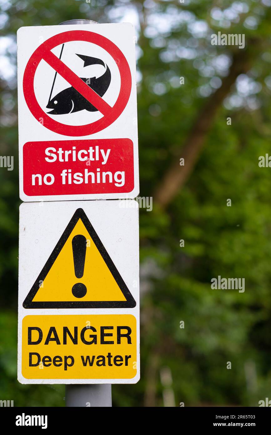 Rigorosamente nessun segno di pesca su un palo con un segno di acqua profonda di pericolo sotto esso. Foto Stock