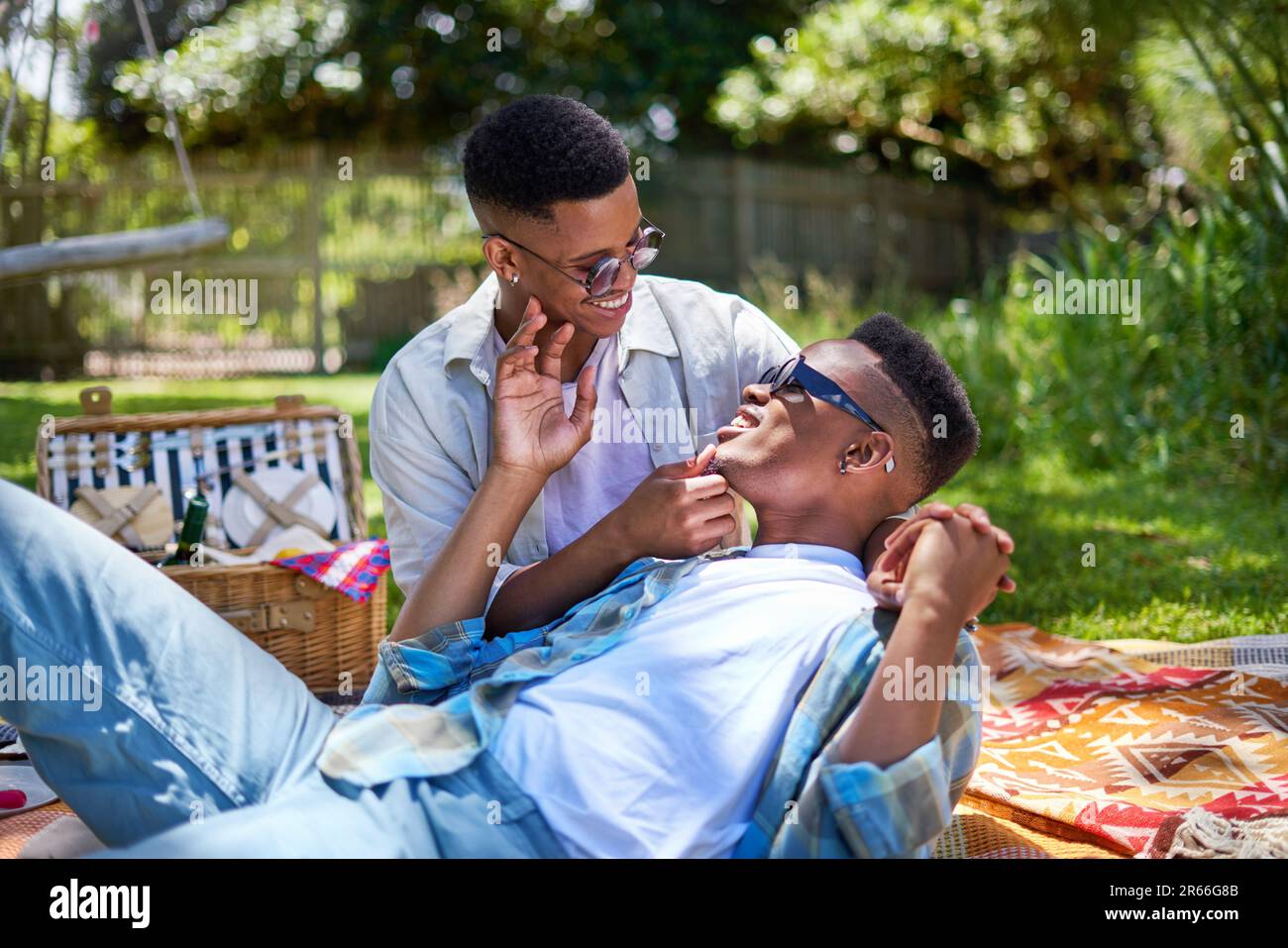 Felice giovane coppia gay maschio cocdling, godendo pic-nic nel parco Foto Stock