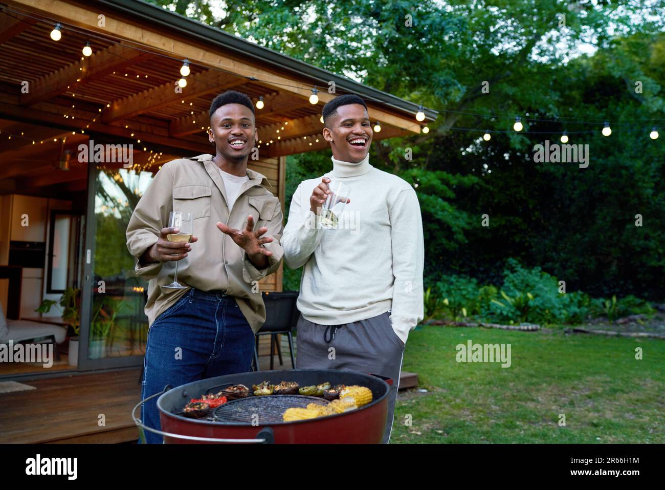 Ritratto felice giovane coppia gay maschio bere e barbecue Foto Stock