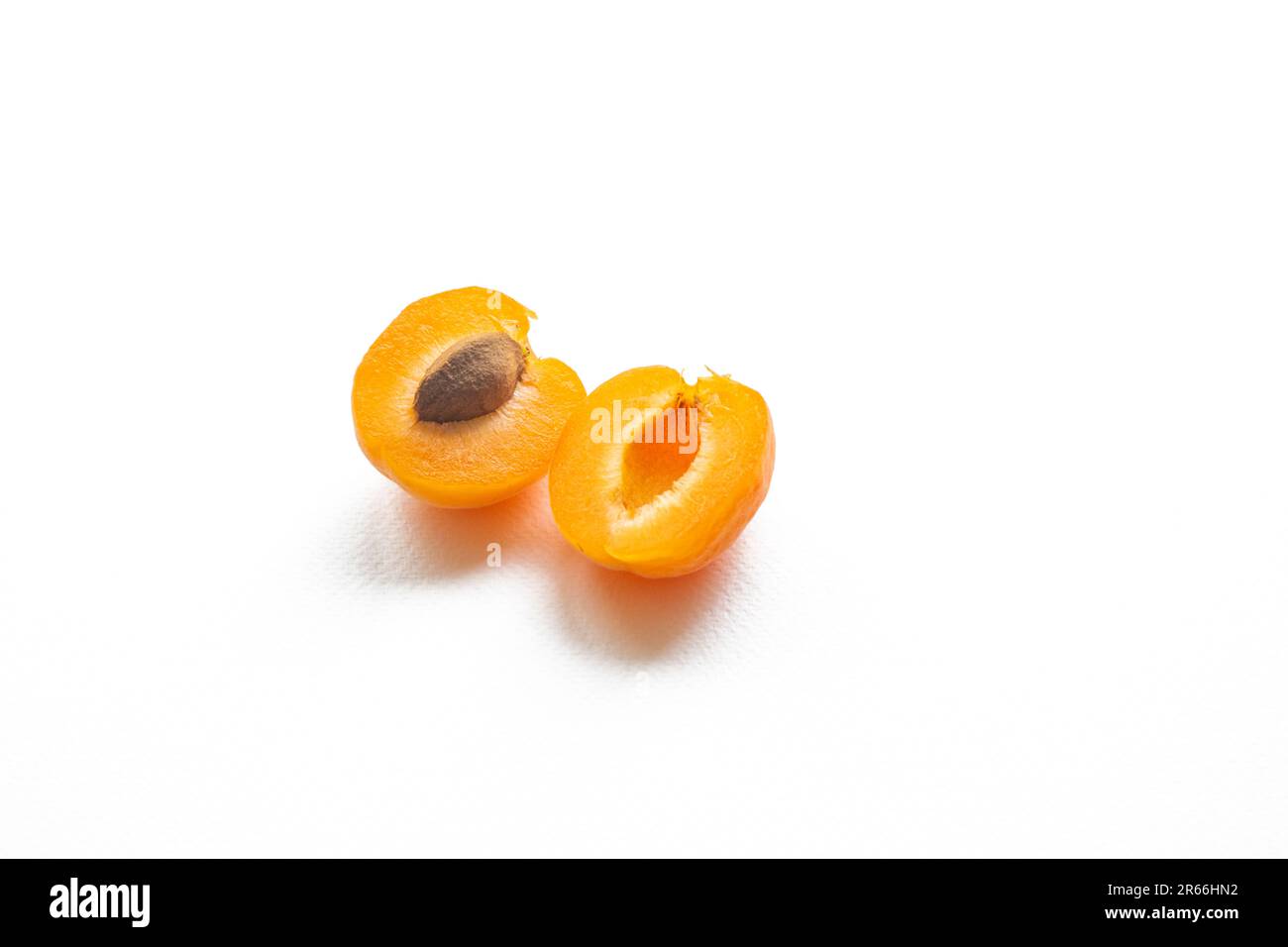Deliziosamente vivace albicocche giallo-arancio, mezza albicocca con pipa, isolate su un fondo bianco puro Foto Stock