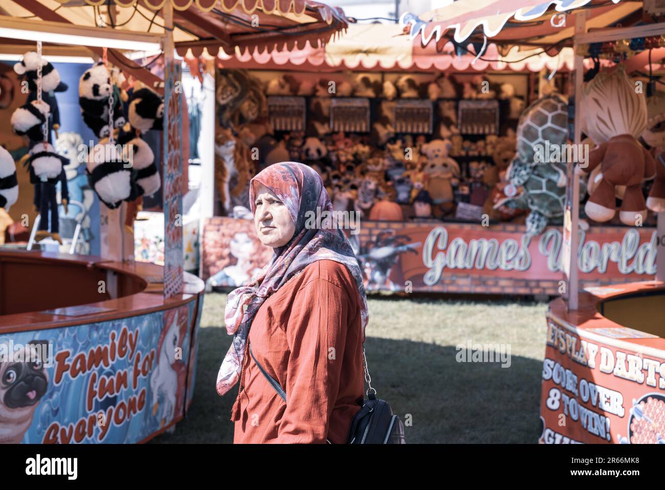 Figura etnica femminile con espressione confusa alla fiera inglese del divertimento estivo Foto Stock
