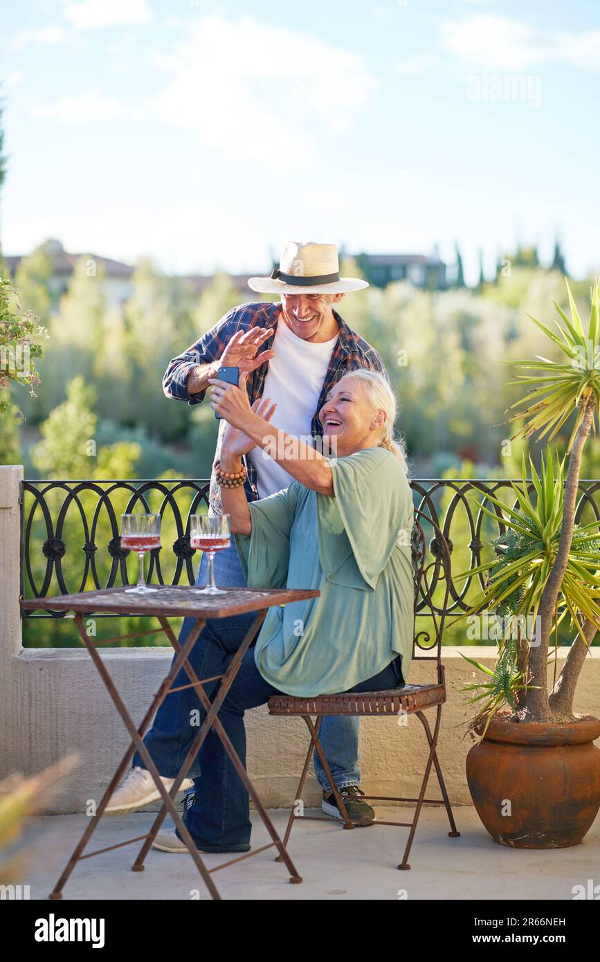 Buon coppia senior in chat video sul balcone estivo Foto Stock