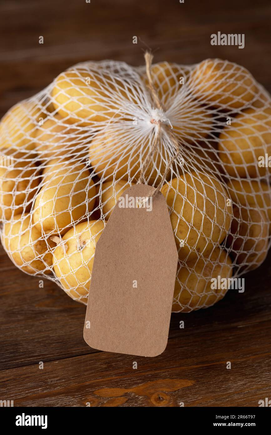 Griglia con patate su fondo di legno marrone con etichetta con spazio vuoto Foto Stock