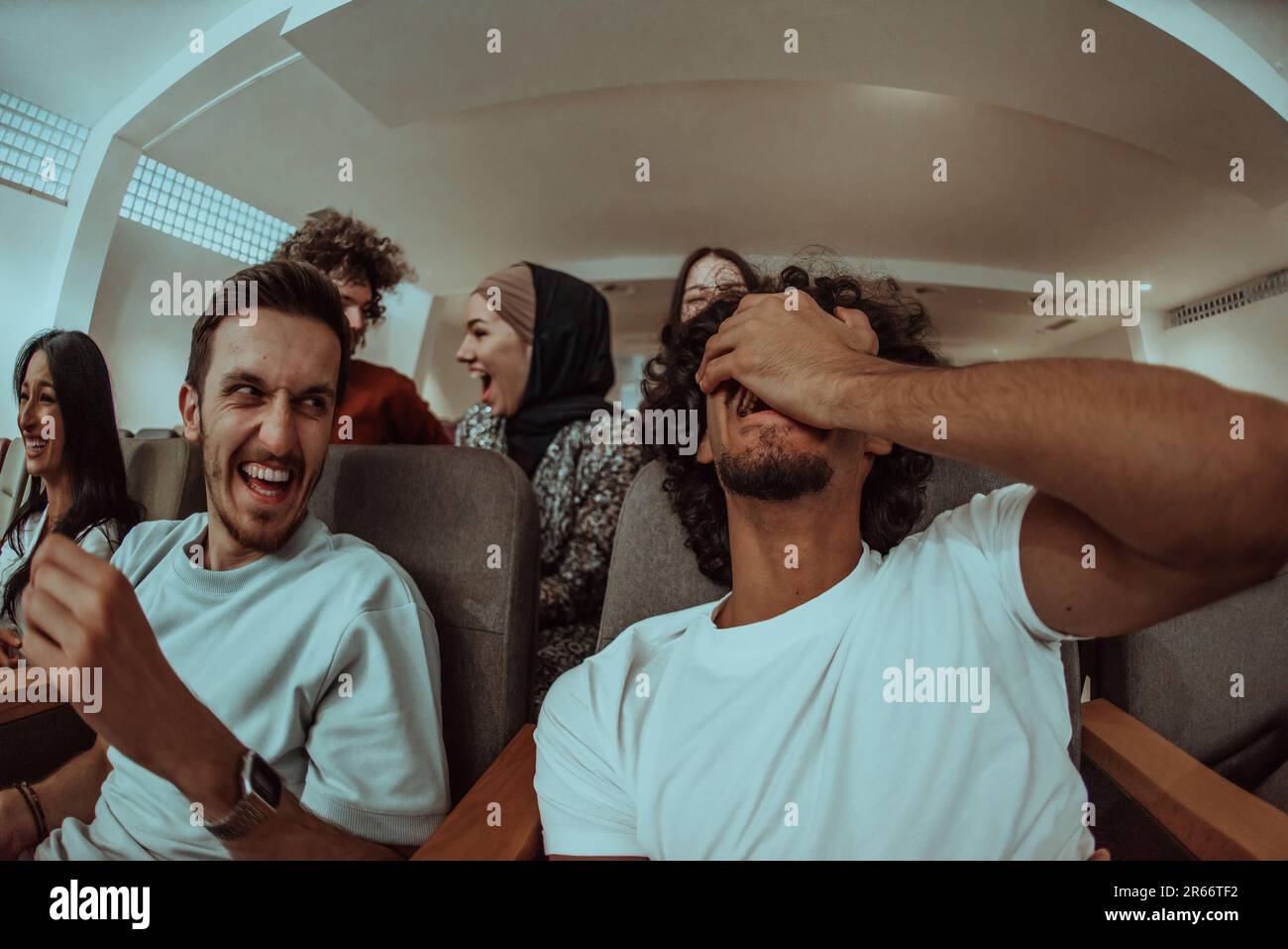 Omedy film, con sorrisi oin un cinema un gruppo diversificato di adolescenti è riunito, guardando un cn loro volti, godendo la risata condivisa e la gioia di Foto Stock