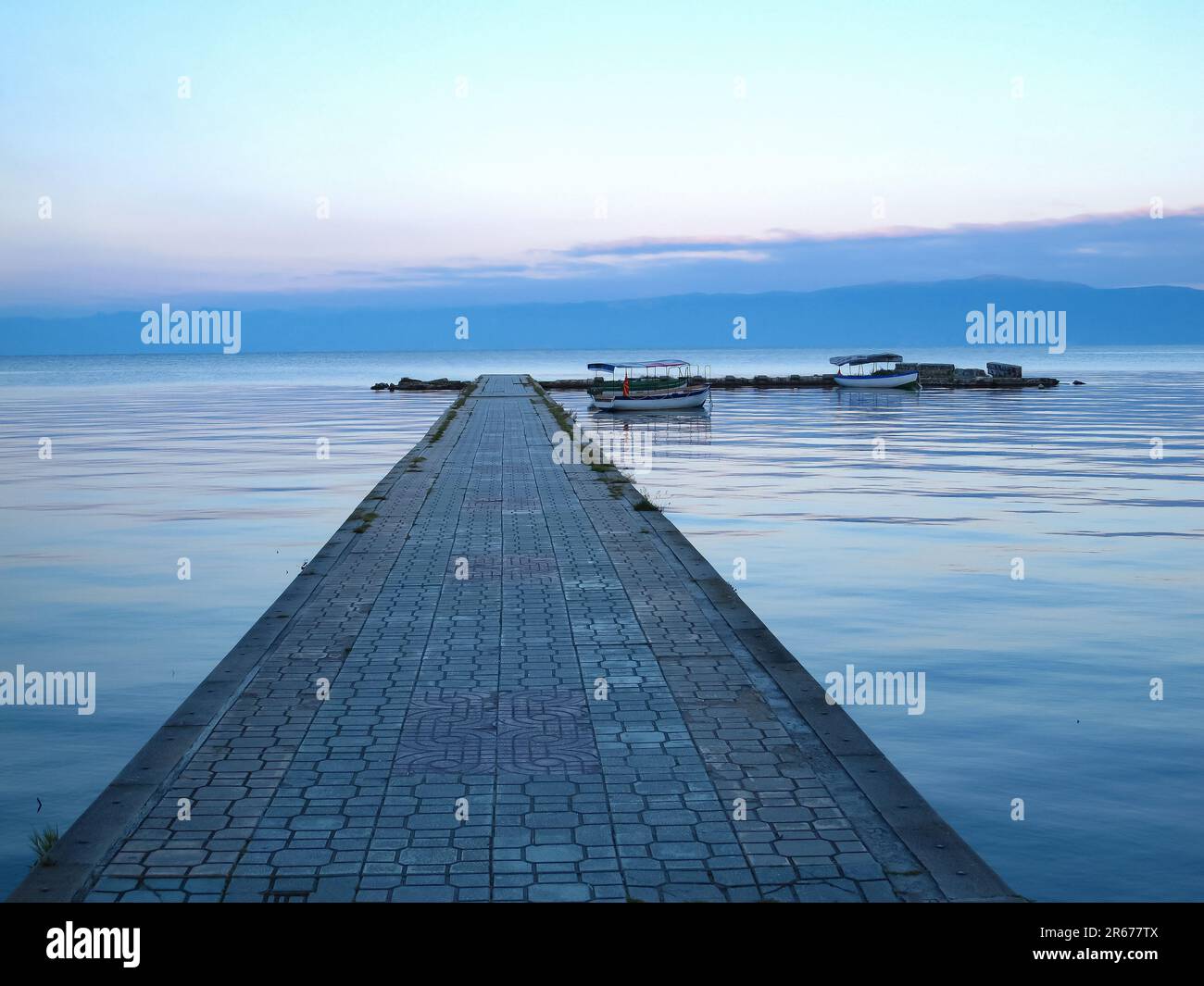 Barche in attesa al molo sul Lago Ohrid una mattina. Foto Stock