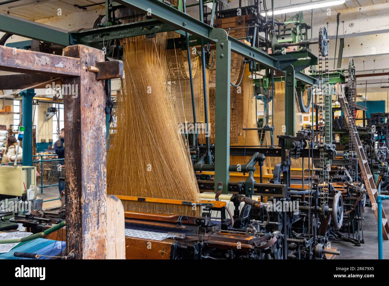 Questa immagine raffigura una moderna macchina industriale utilizzata per creare rocche di filato a forma di cono, che forniscono il materiale necessario per i progetti di lavorazione a maglia Foto Stock