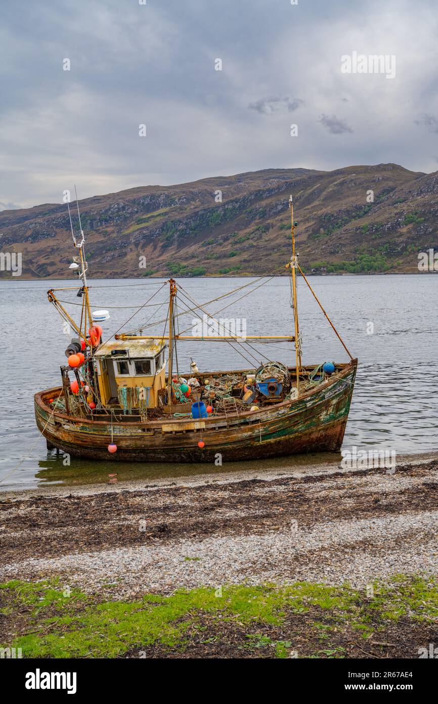 Nave da pesca distrutta sulla riva del mare a Ullapool Scozia Foto Stock
