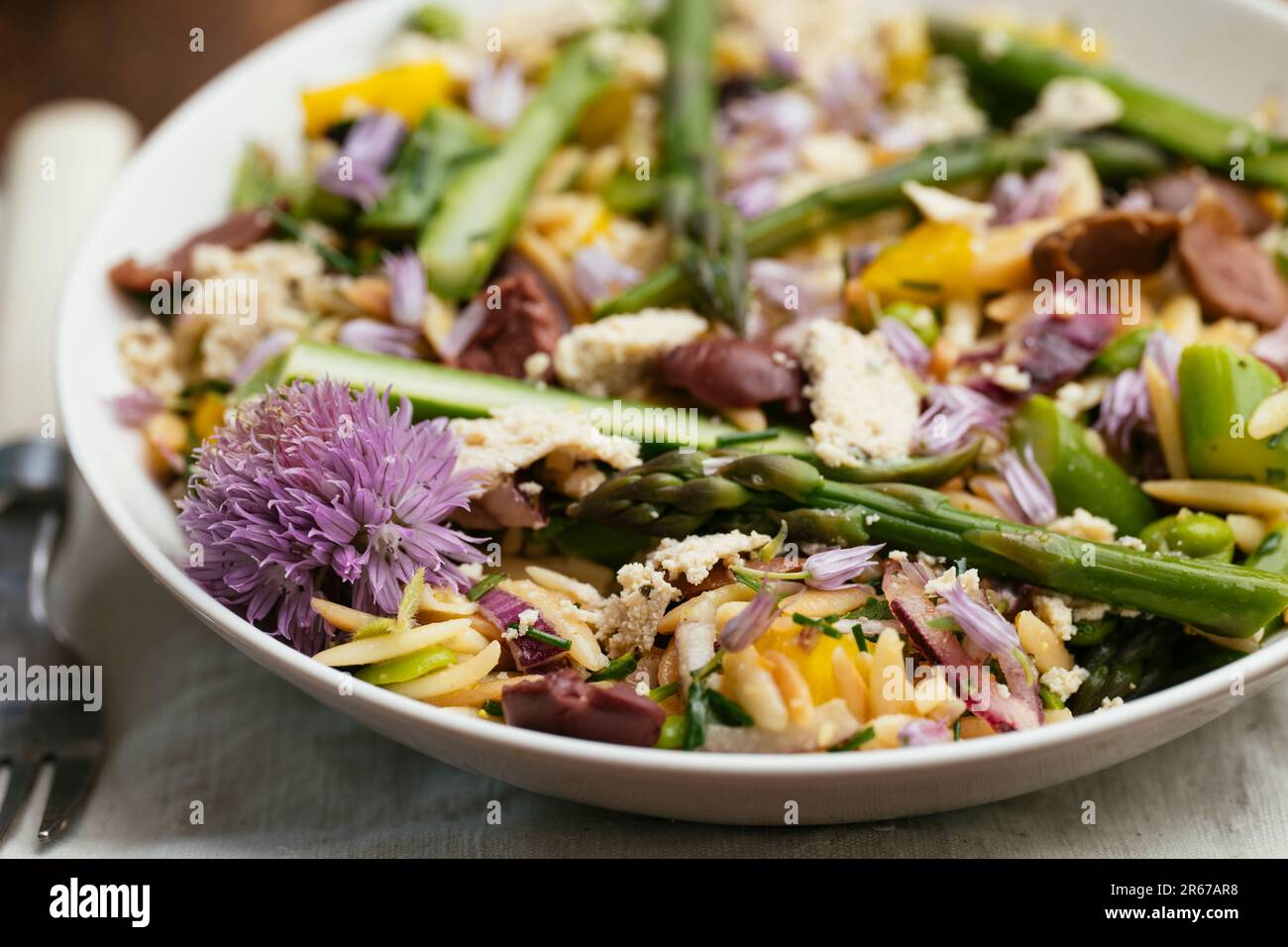 Ciotola con insalata di orzo fatta in casa con asparagi, fave e olive kalamata Foto Stock