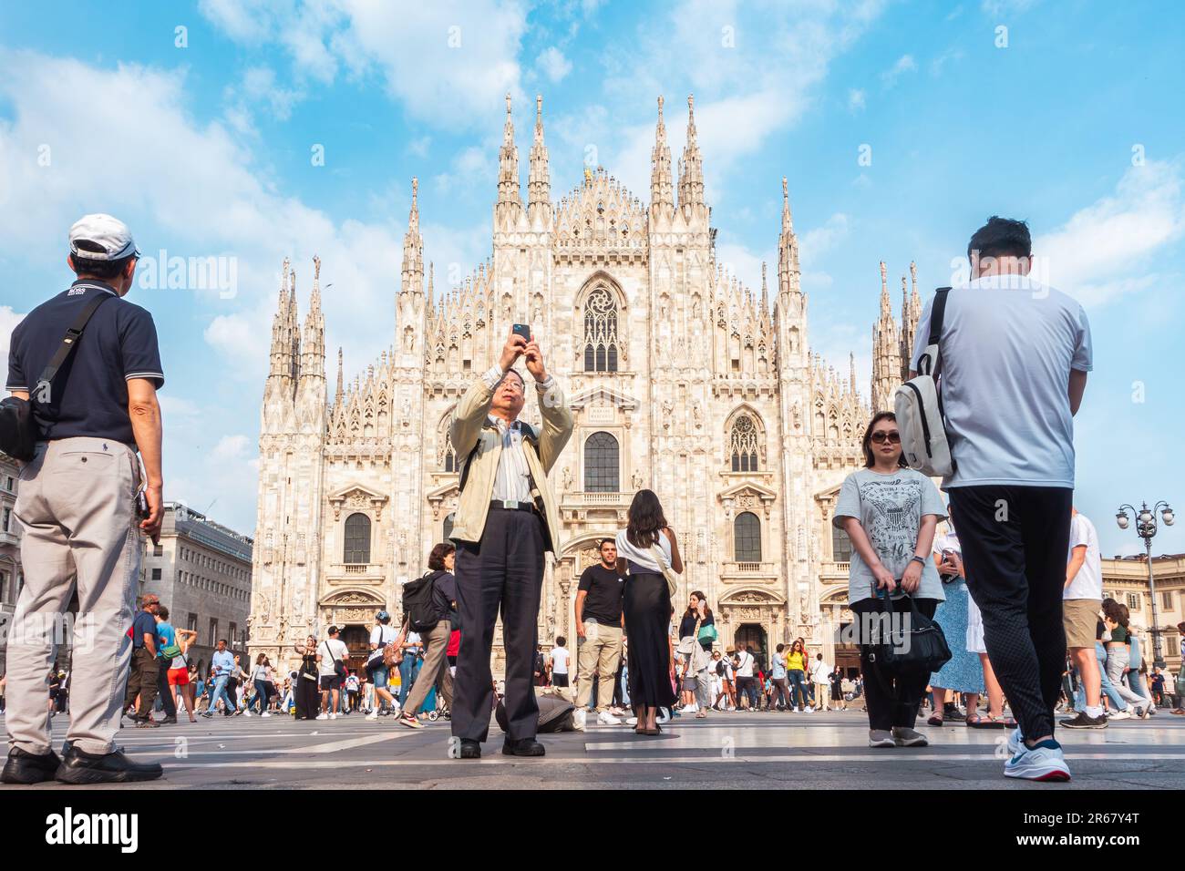 Italia, Milano Piazza Duomo, molti turisti scattano foto. Una folla di persone scatta foto in Piazza del Duomo. Turisti asiatici a Milano. Foto Stock