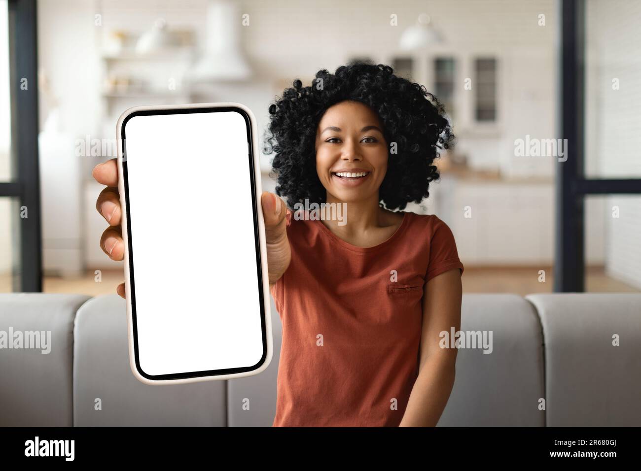 Pubblicità mobile. Happy Black Woman che mostra uno smartphone Big Blank  alla fotocamera Foto stock - Alamy