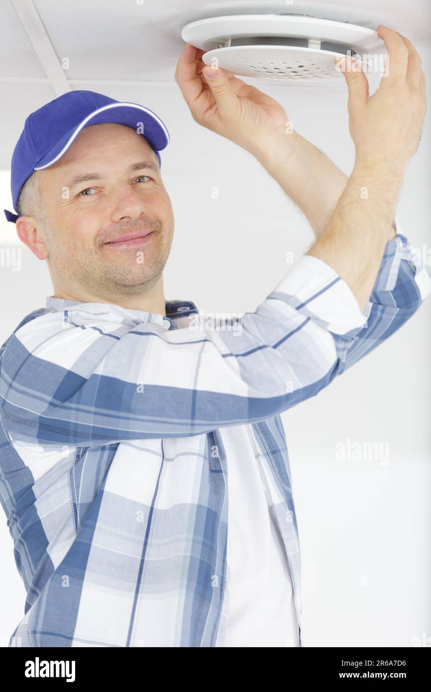 elettricista uomo che fissa una nuova lampada per una nuova casa Foto Stock