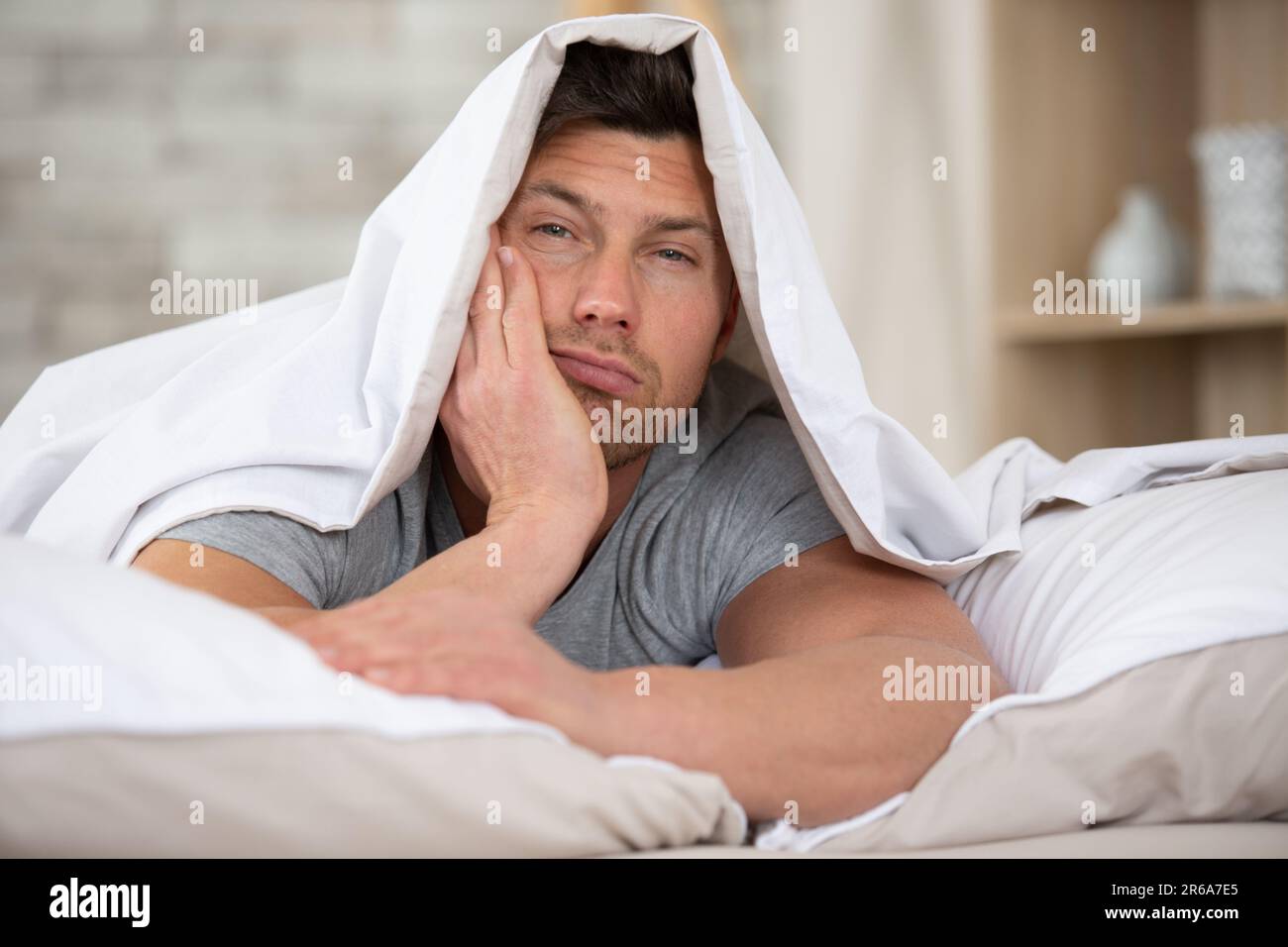 giovane uomo a letto che cerca di dormire Foto stock - Alamy