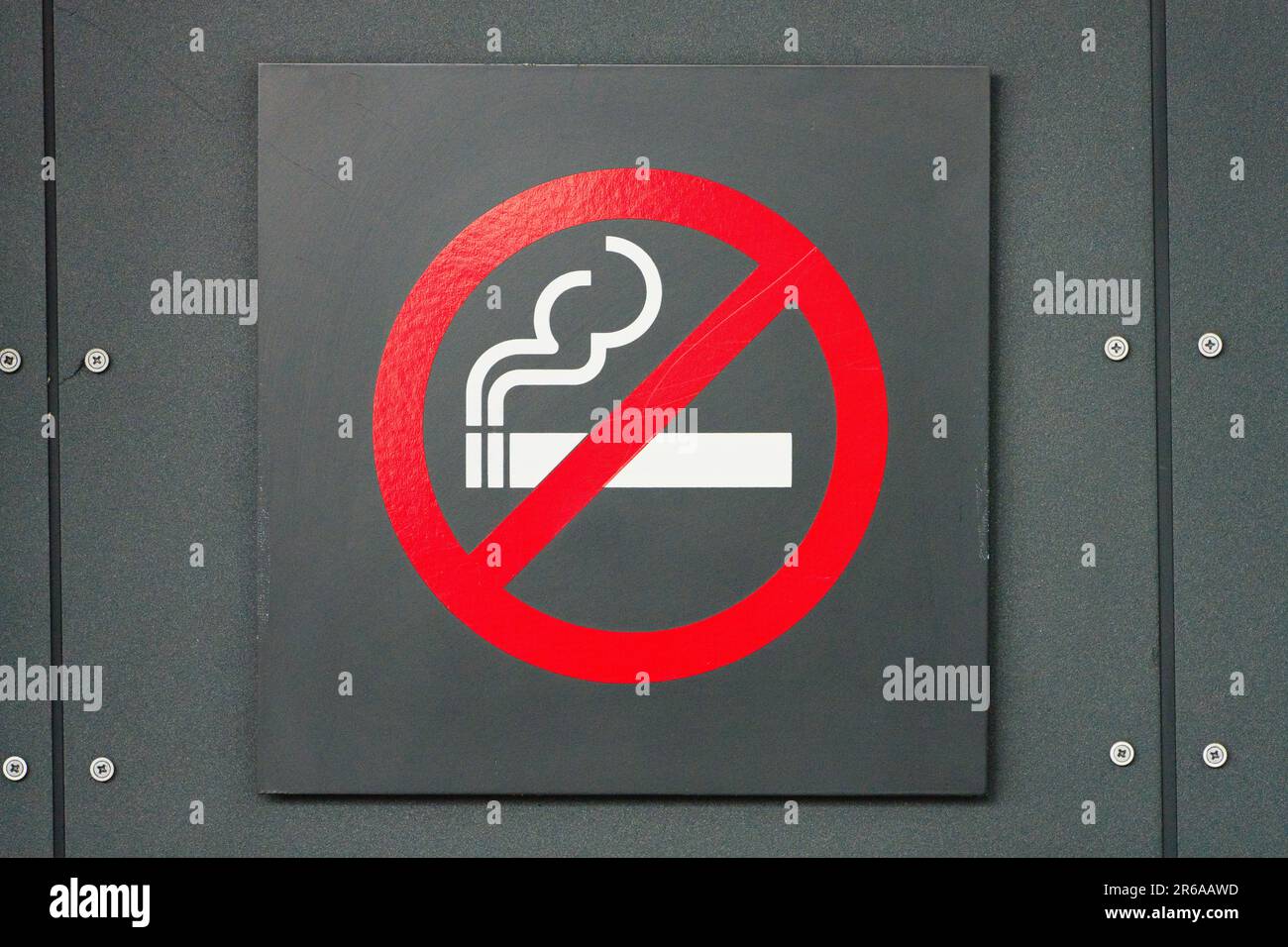 Cartello divieto di fumo e simbolo di divieto generale con anello rosso e sfondo di metallo scuro, aeroporto di Melbourne, Australia. Foto Stock