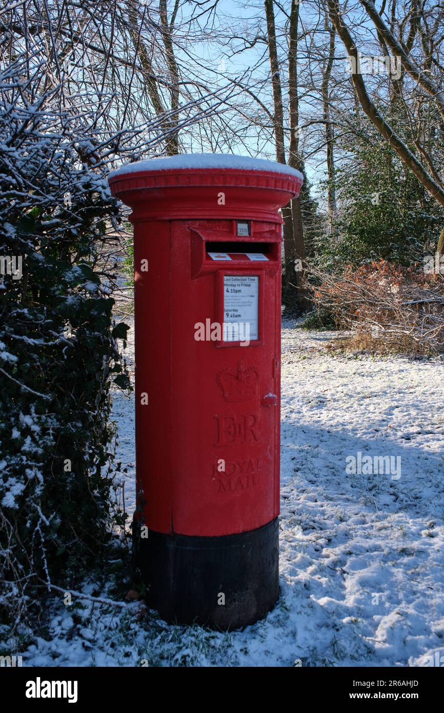 Una casella di posta rossa coperta di neve in un villaggio rurale Cheshire Foto Stock