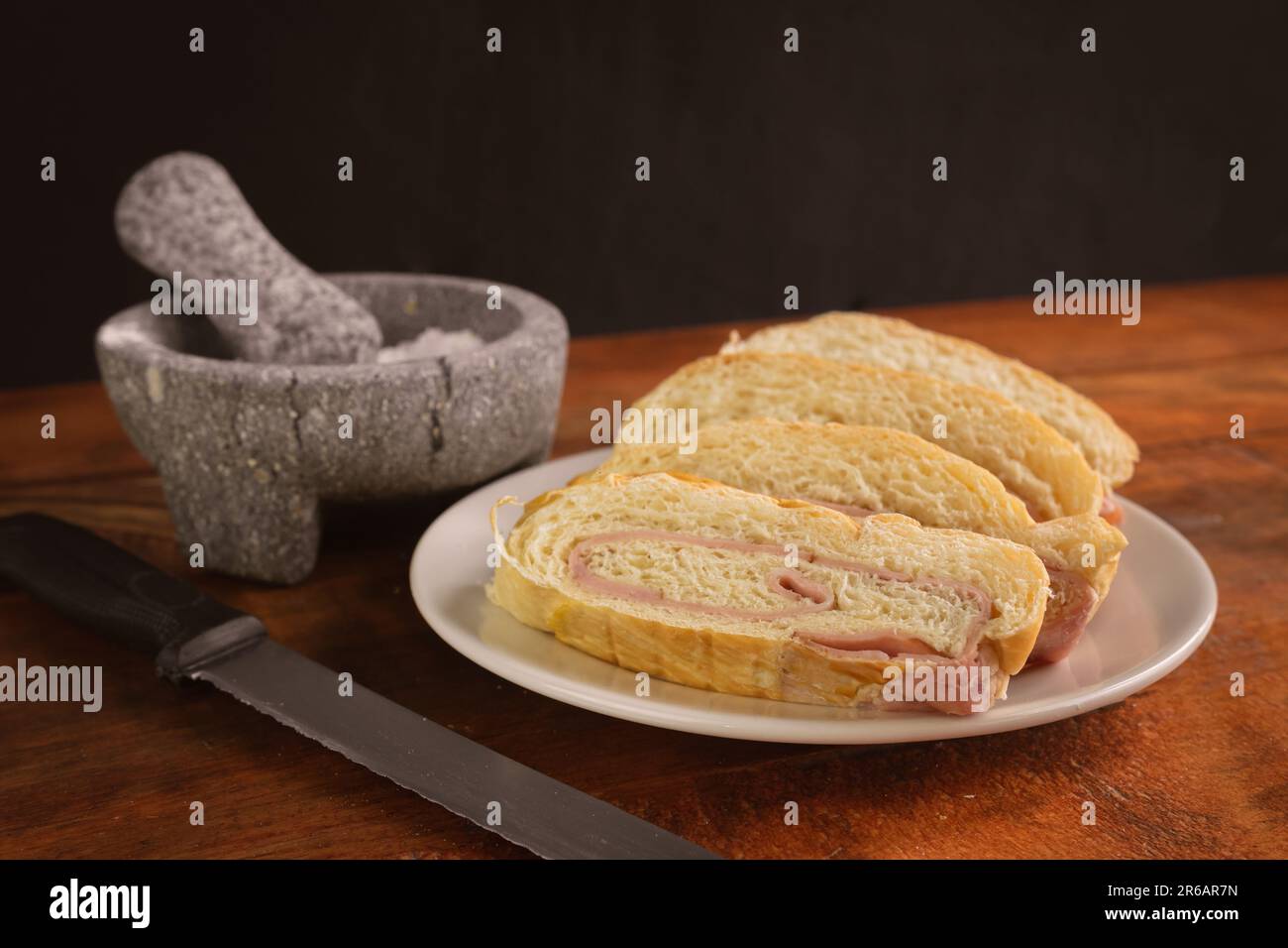 Un panino di prosciutto tagliato a metà su un tavolo di legno Foto Stock