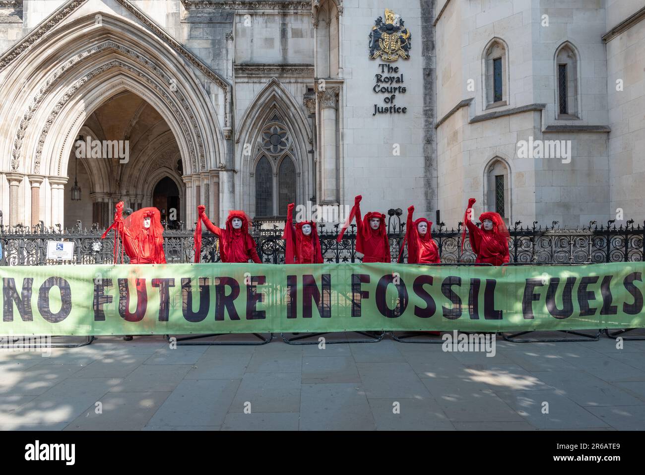 Londra, Regno Unito. 8 giugno, 2023. La troupe mimo della Brigata Rossa di Rebel si unisce agli oppositori di un progetto proposto di trivellazione per il gas nel Surrey che si raduna al di fuori delle Corti reali di Giustizia all'inizio di un controllo giudiziario. La domanda originale di ricerca di combustibili fossili nel 2020 è stata respinta dal Surrey County Council, ma successivamente approvata dal ministro Michael Gove. Il Consiglio di Waverley Borough ha impugnato questa decisione e ha ottenuto un controllo giudiziario. Tra gli argomenti sollevati vi sono le emissioni di gas serra e la vicinanza del sito ad un'area di straordinaria bellezza naturale (AONB). Credit: Ron Fassbender/Alamy Live News Foto Stock