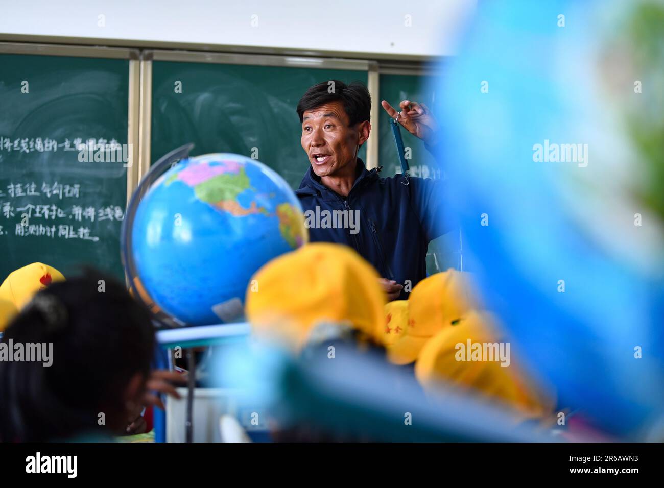 (230608) -- TINGRI, 8 giugno 2023 (Xinhua) -- Damba Rinqen, vice presidente di una scuola elementare di Zhaxizom Township, istruisce gli studenti in una classe di scienza nella contea di Tingri, Xigaze City, regione autonoma del Tibet del sud-ovest della Cina, 5 giugno 2023. La scuola elementare di Zhaxizom Township è la scuola più vicina al Monte Qomolangma, con una distanza di poco più di 40 chilometri. Per soddisfare le diverse esigenze degli studenti, la scuola ha istituito classi di interesse come pianoforte, informatica, arte, trasmissione, sport, danza e artigianato. Attualmente, la scuola elementare ha un solo pianoforte. Foto Stock