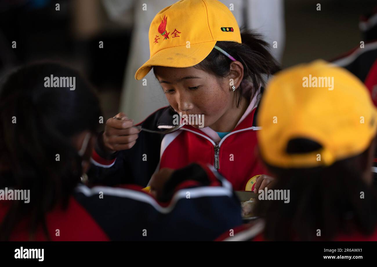 (230608) -- TINGRI, 8 giugno 2023 (Xinhua) -- gli studenti pranzano nella mensa di una scuola elementare del comune di Zhaxizom nella contea di Tingri, Xigaze City, regione autonoma del Tibet nel sud-ovest della Cina, 5 giugno 2023. La scuola elementare di Zhaxizom Township è la scuola più vicina al Monte Qomolangma, con una distanza di poco più di 40 chilometri. Per soddisfare le diverse esigenze degli studenti, la scuola ha istituito classi di interesse come pianoforte, informatica, arte, trasmissione, sport, danza e artigianato. Attualmente, la scuola elementare ha un solo pianoforte. Pertanto, le tastiere elettroniche sono Foto Stock