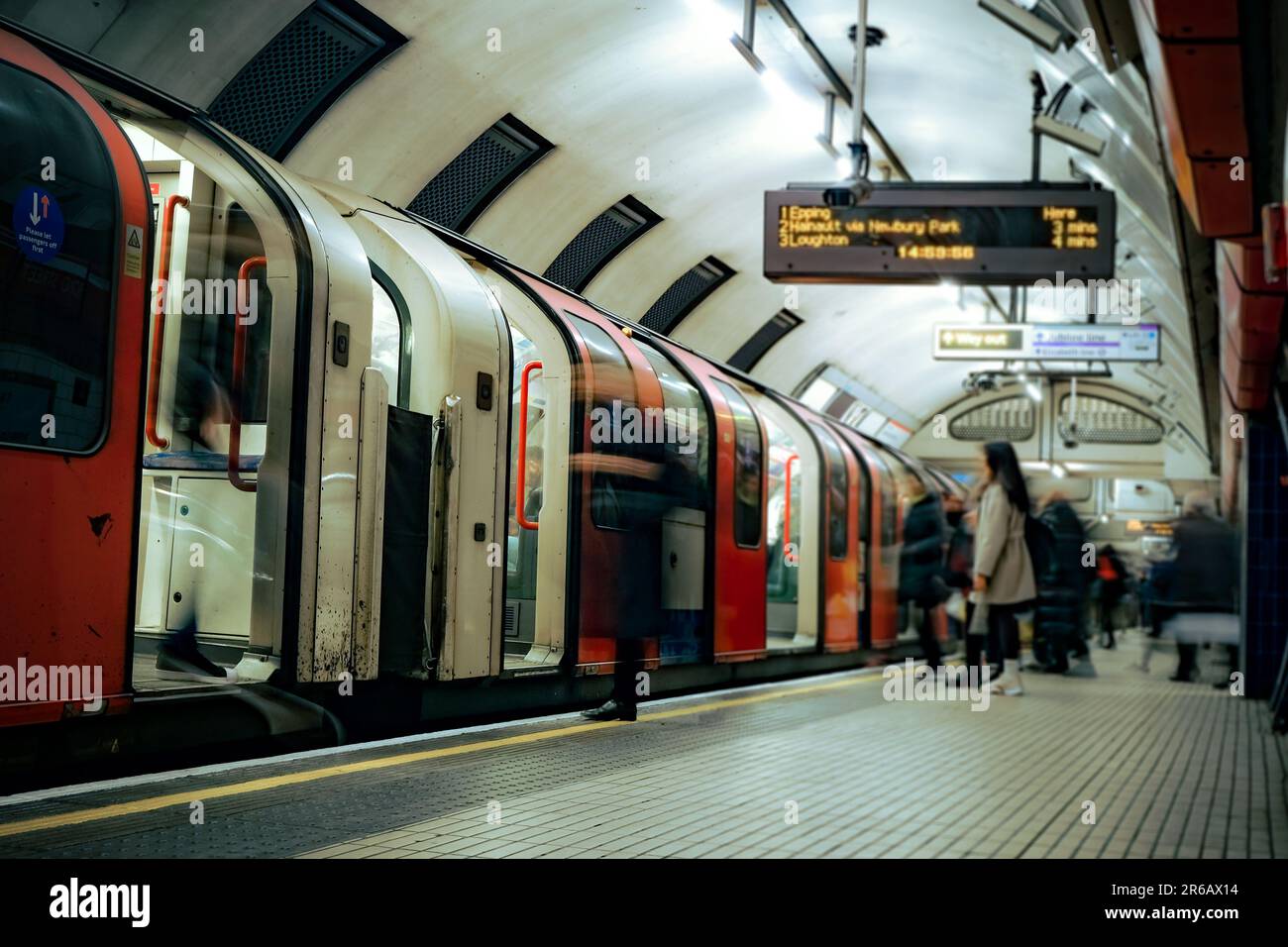 Piattaforma ferroviaria di Londra - vista sfocata in movimento con persone anonime Foto Stock