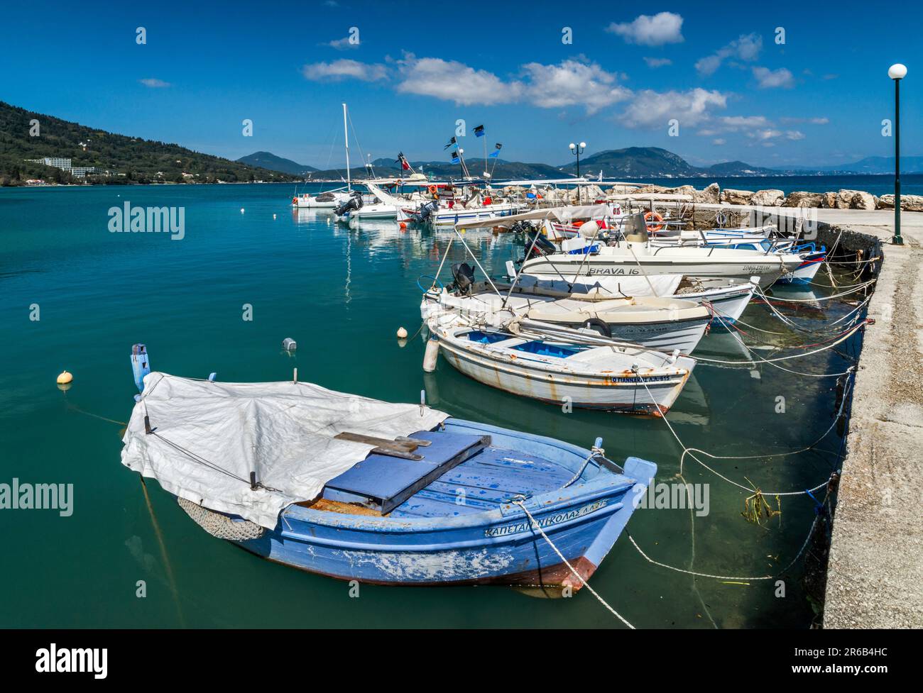 Barche ormeggiate al molo nel bacino del porto nel villaggio di Boukari, isola di Corfù, Grecia Foto Stock