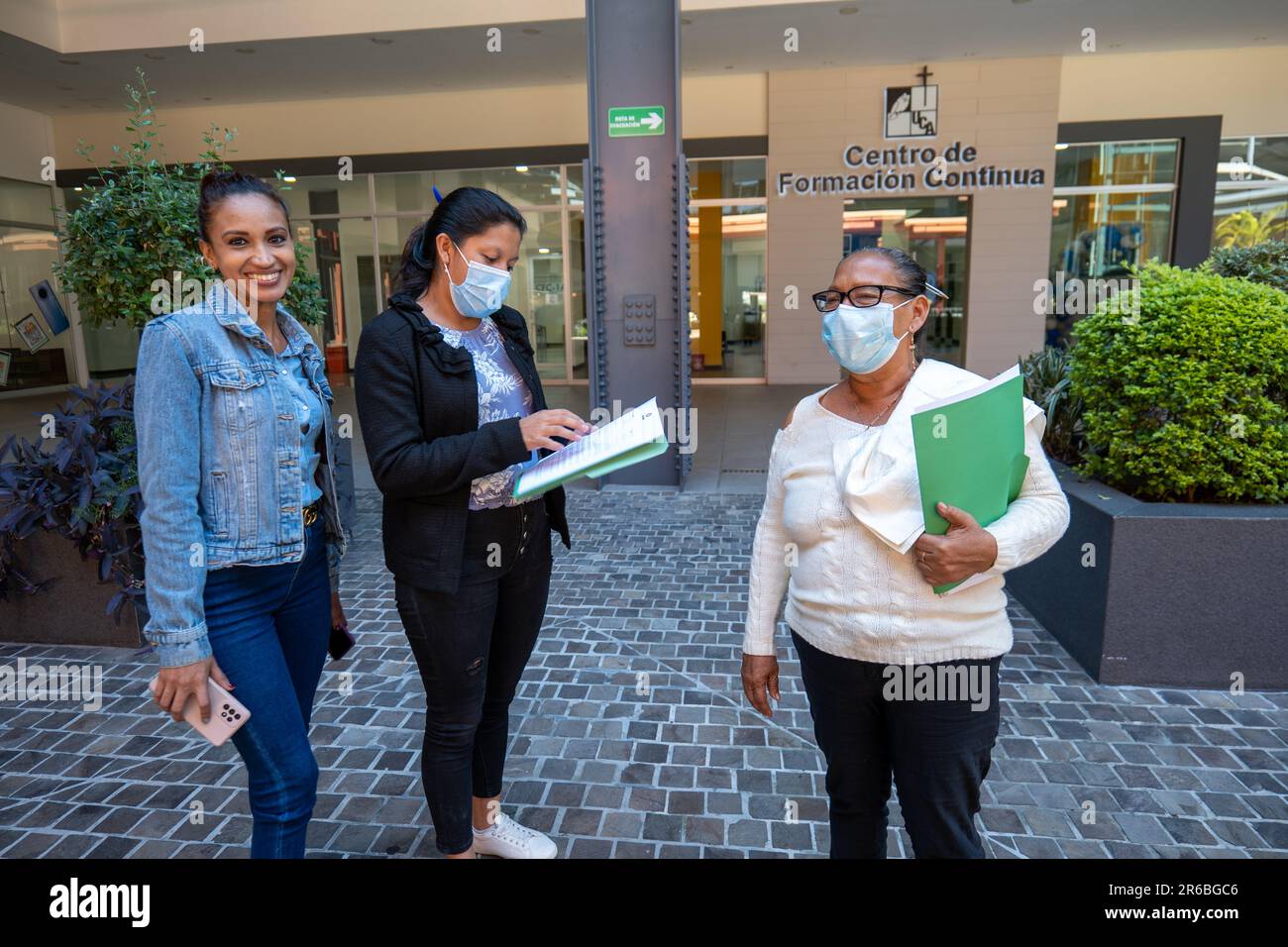 San Salvador, la Libertad, El Salvador - 15 ottobre 2022: Due donne Brunette che indossano maschere e parlano l'una con l'altra mentre una bella donna guarda Foto Stock