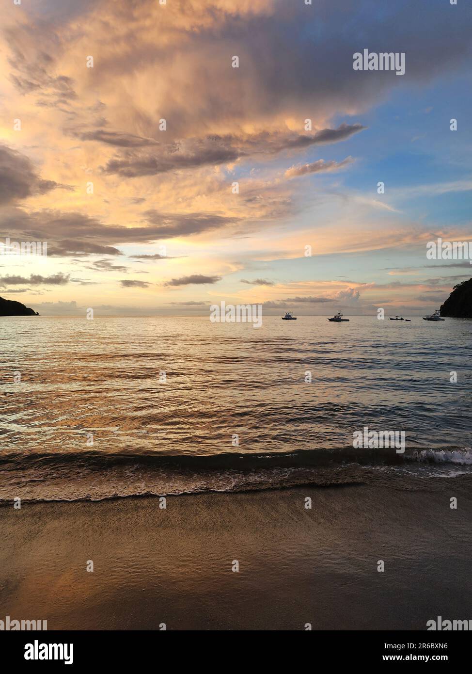 Tramonto colorato in spiaggia tropicale con acqua calma Foto Stock