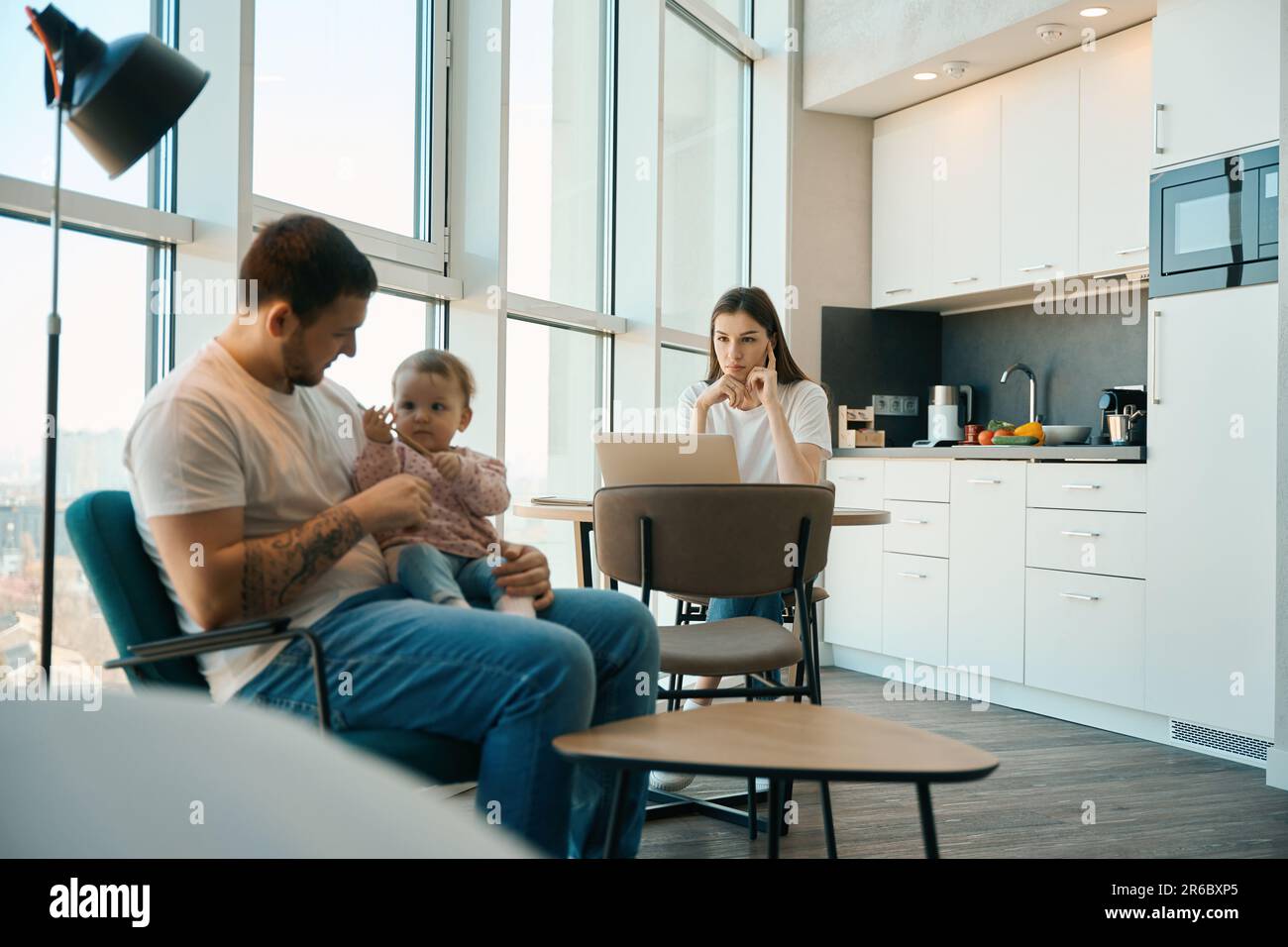 Il padre premuroso sta babysitting la sua figlia piccola nella cucina Foto Stock