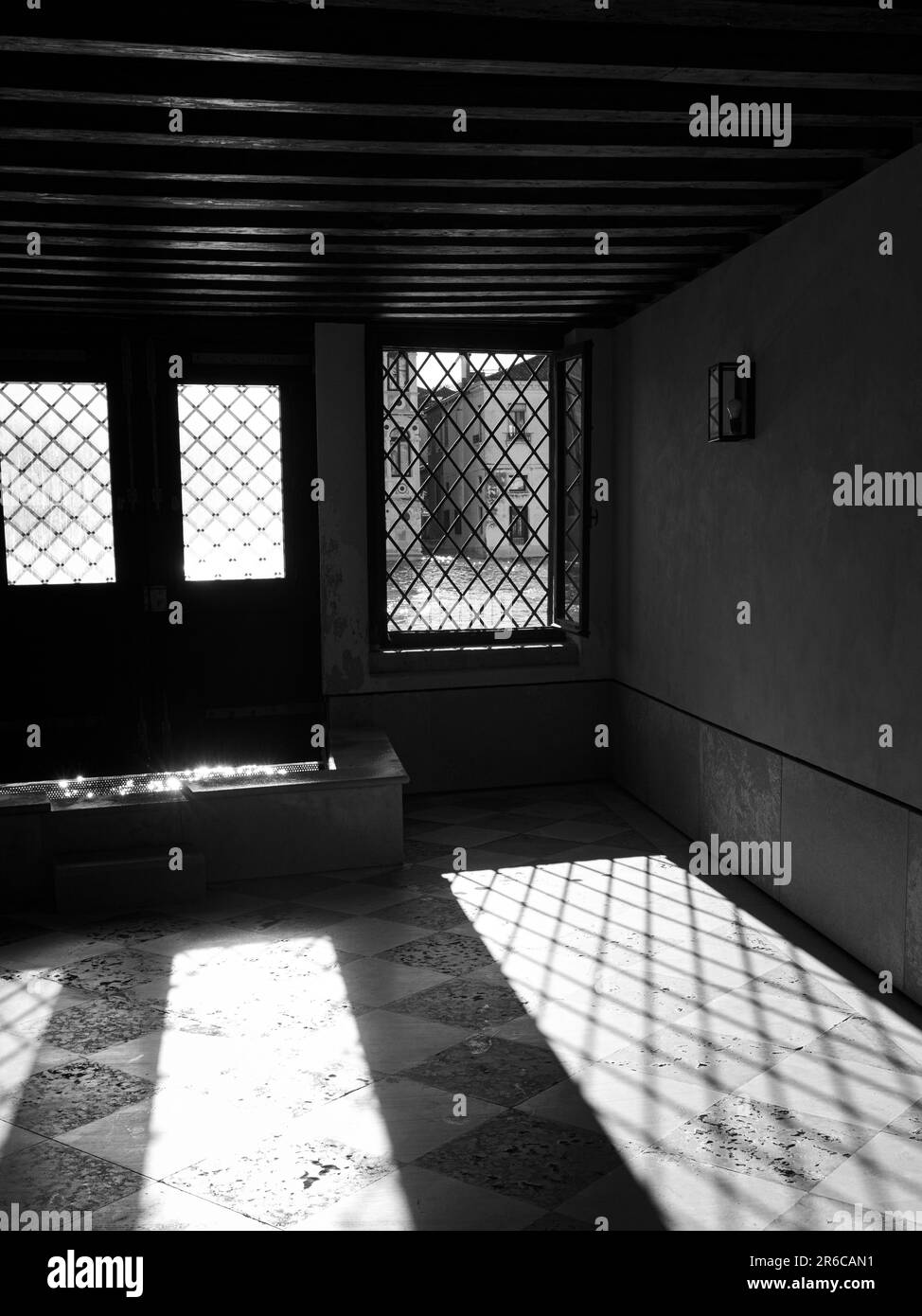 Questa foto è caratterizzata da uno spazio abitativo contemporaneo con numerose grandi finestre e una tavolozza di colori minimalisti di tonalità scure e bianco e nero Foto Stock