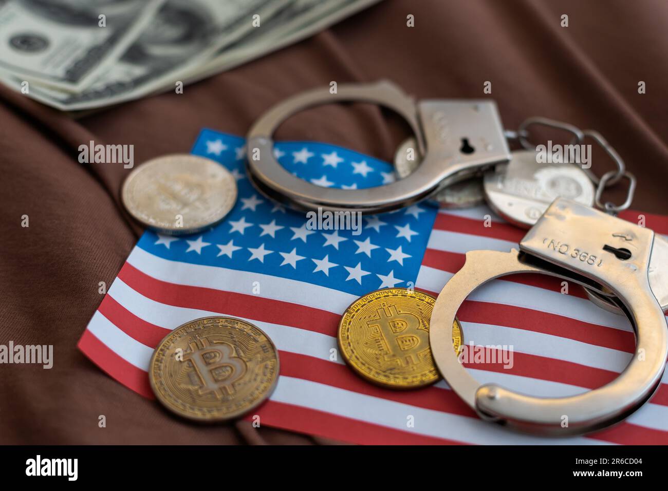 Criptovaluta Golden Bitcoins con manette sulle fatture in dollari. Concetto di criminalità digitale, arresto o hacking. Manette dollari e bitcoins sul tavolo Foto Stock
